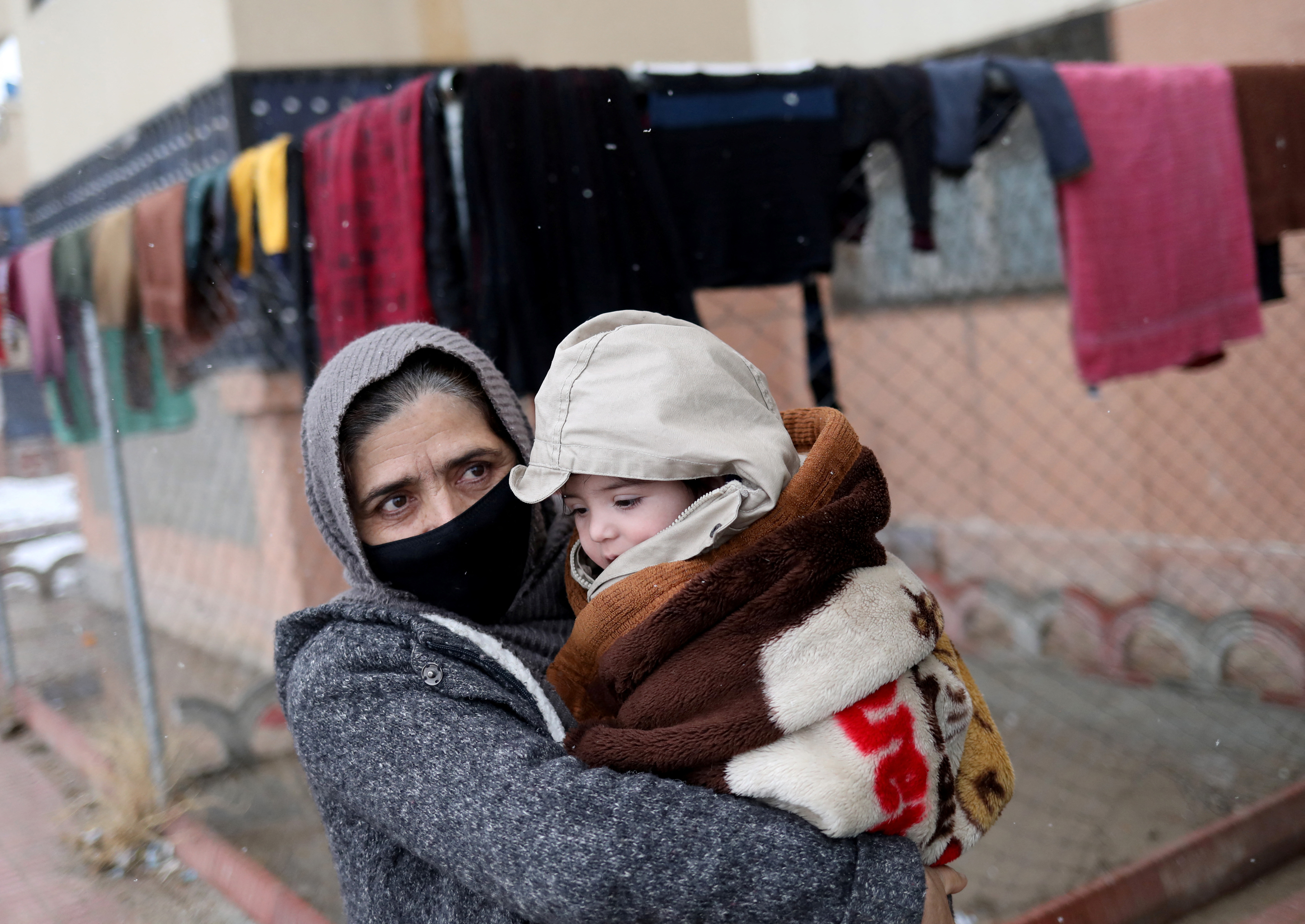 Baby Sohail Ahmadi is carried by his grandmother as they leave the house of Hamid Safi, a 29-year-old taxi driver who had found Sohail at Kabul airport