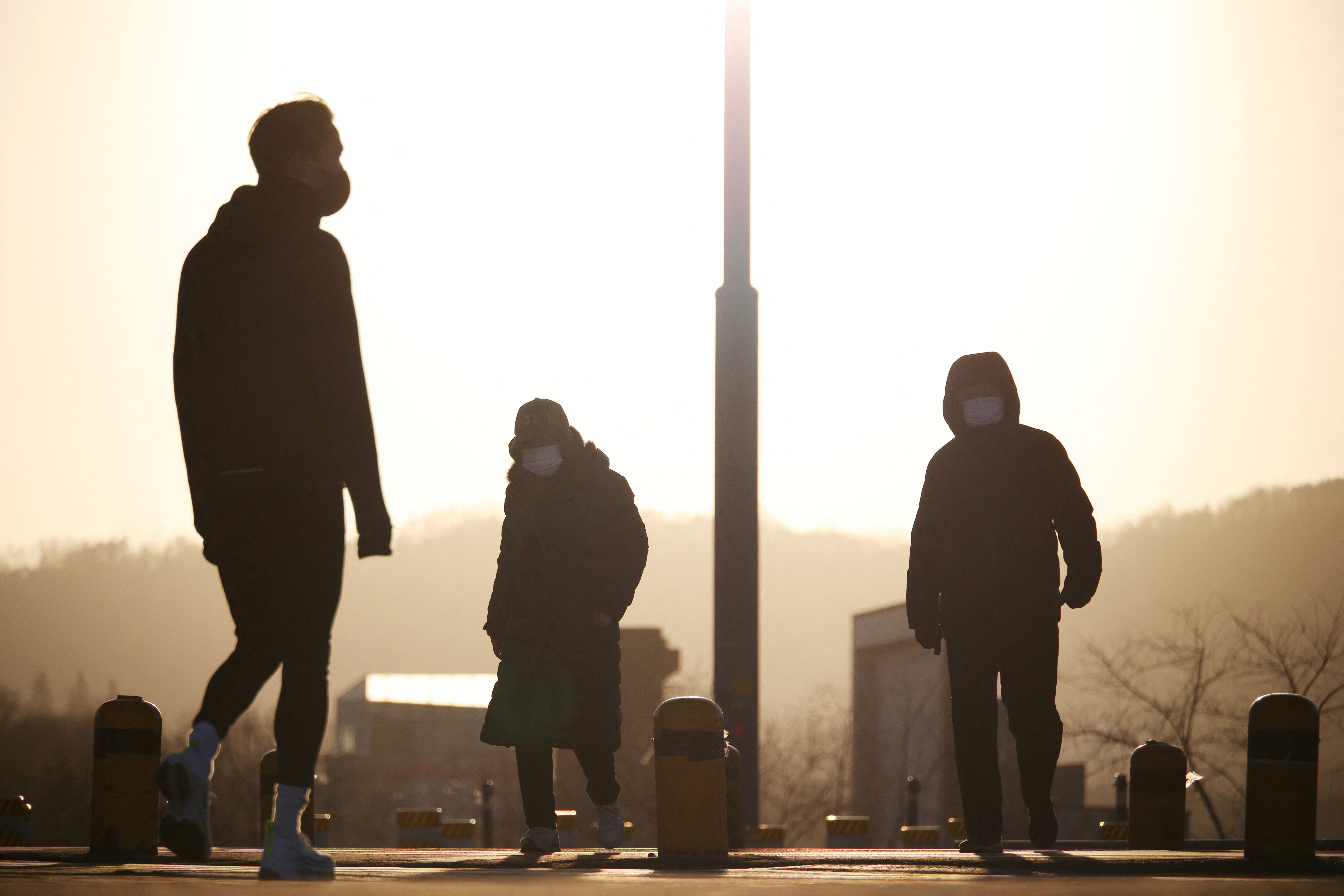 People wearing masks take a walk on a cold winter’s day at a Han river park in Seoul