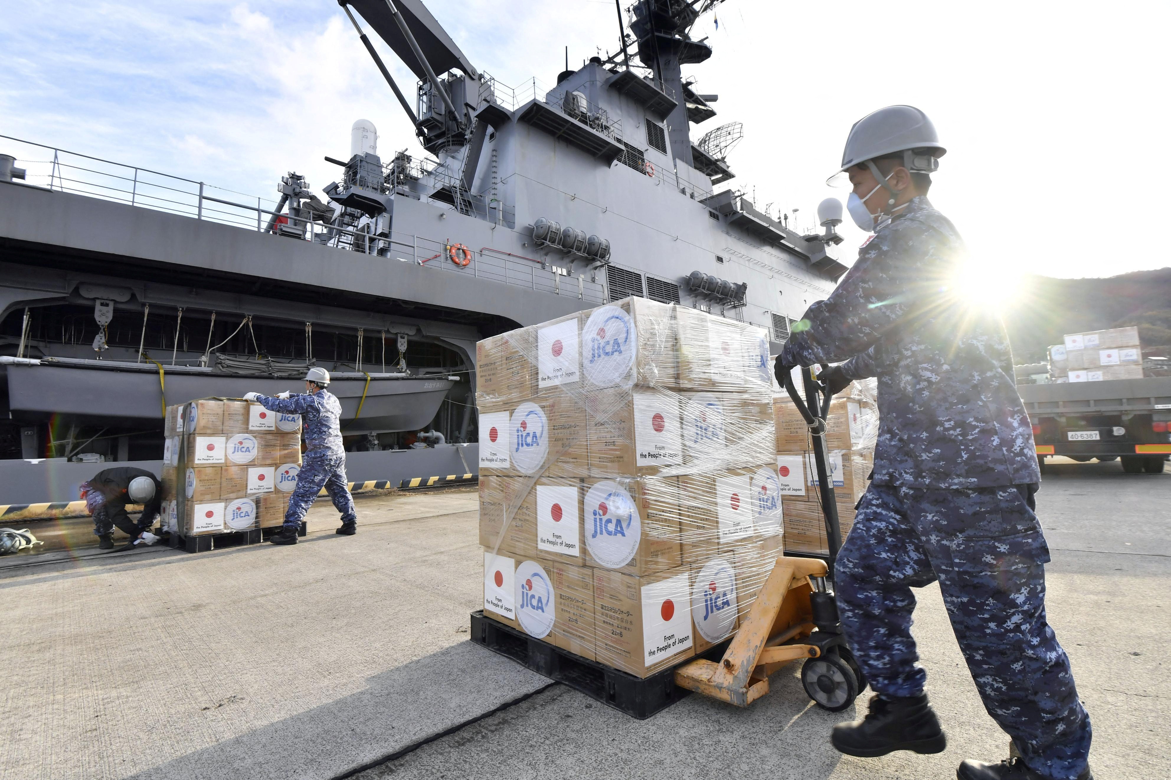 Japan Self-Defense Forces officers load relief supplies bound for Tonga onto the Japan Maritime Self-Defense Force’s transport vessel Osumi at its base in Hiroshima [Kyodo via Reuters]