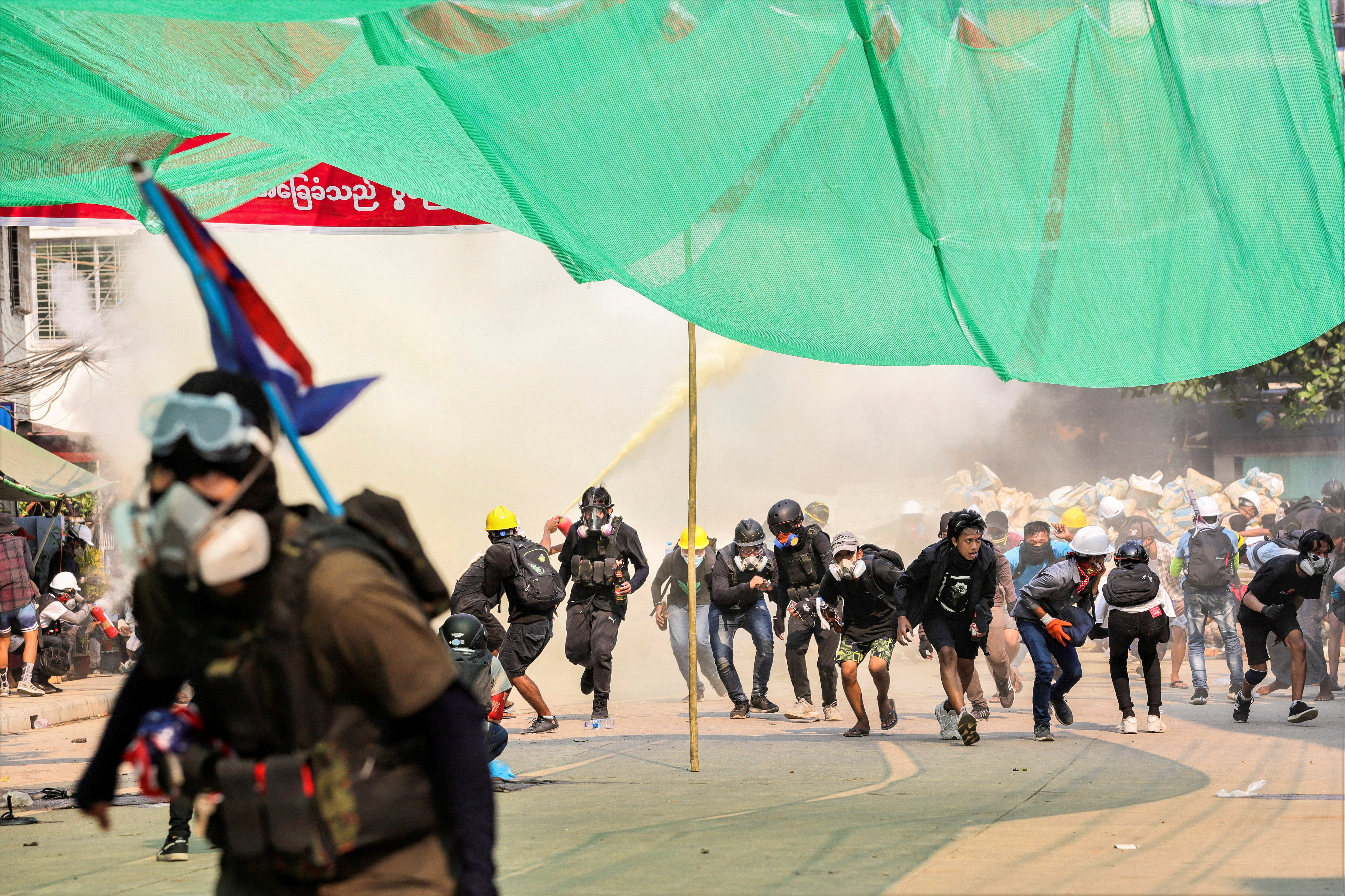 Protesters running in Myanmar