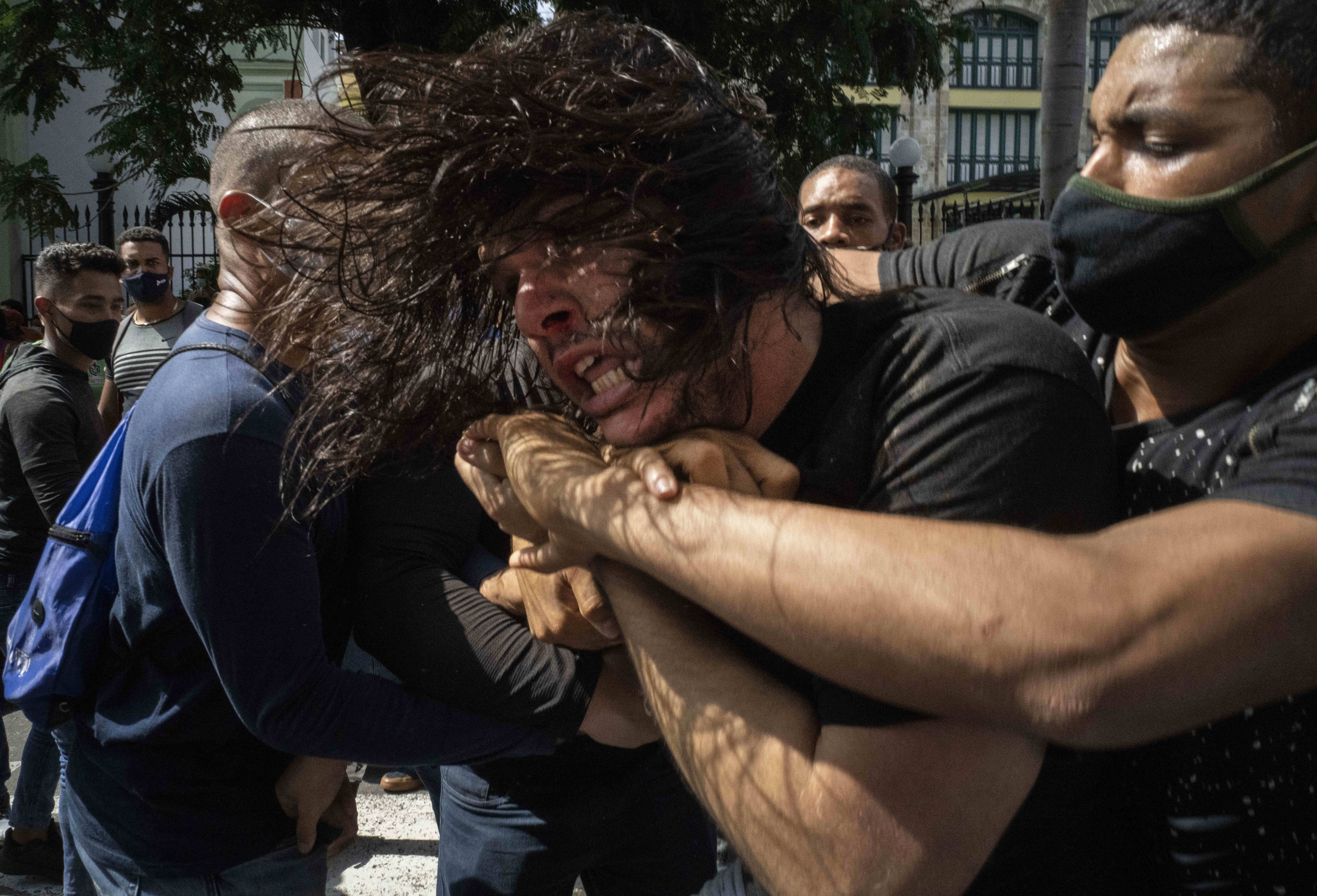 Plainclothes police detained protesters during a July demonstration against high prices, food shortages and power outages