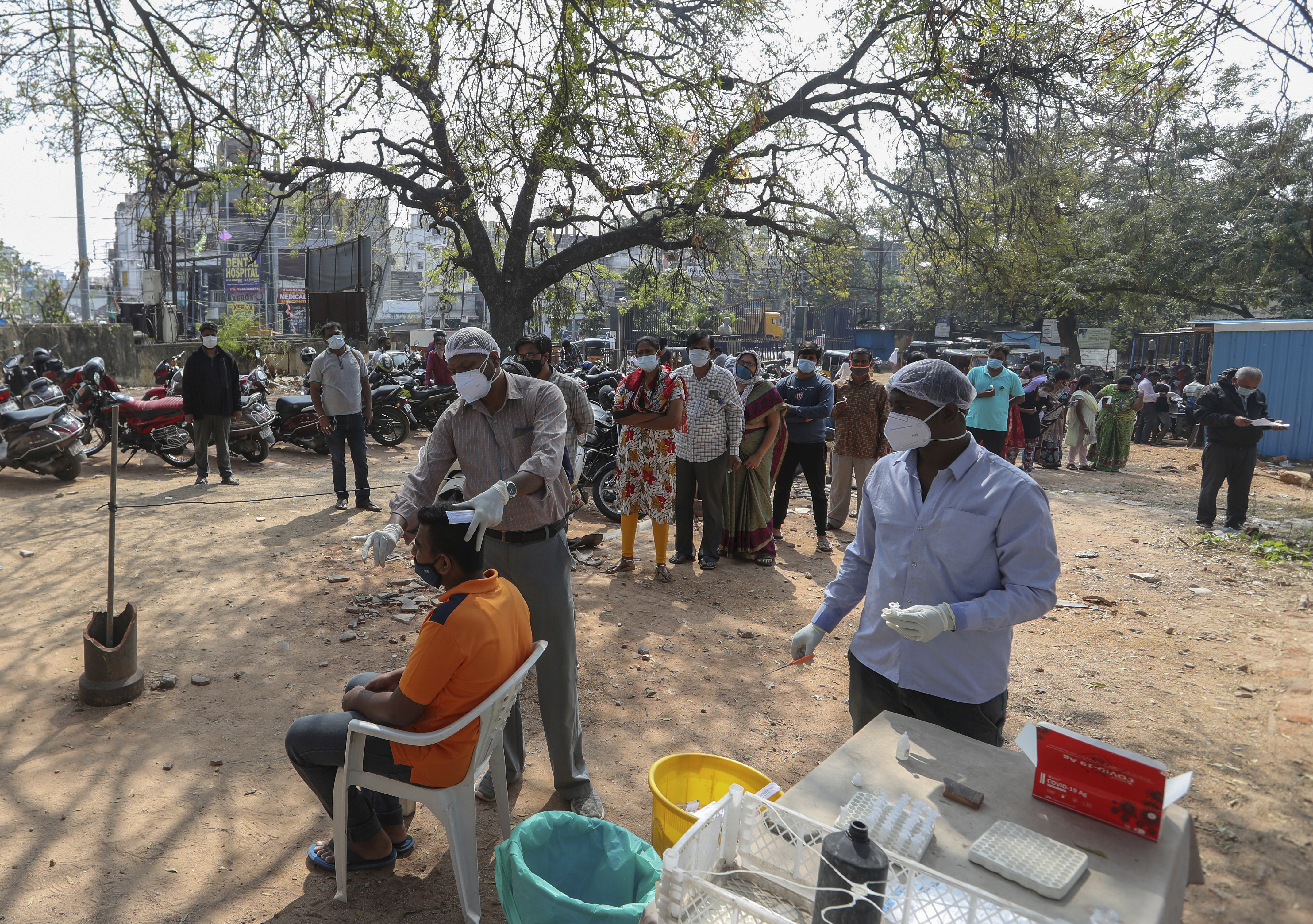 A health worker takes a swab sample of a man to test for COVID-19 at a government hospital in Hyderabad