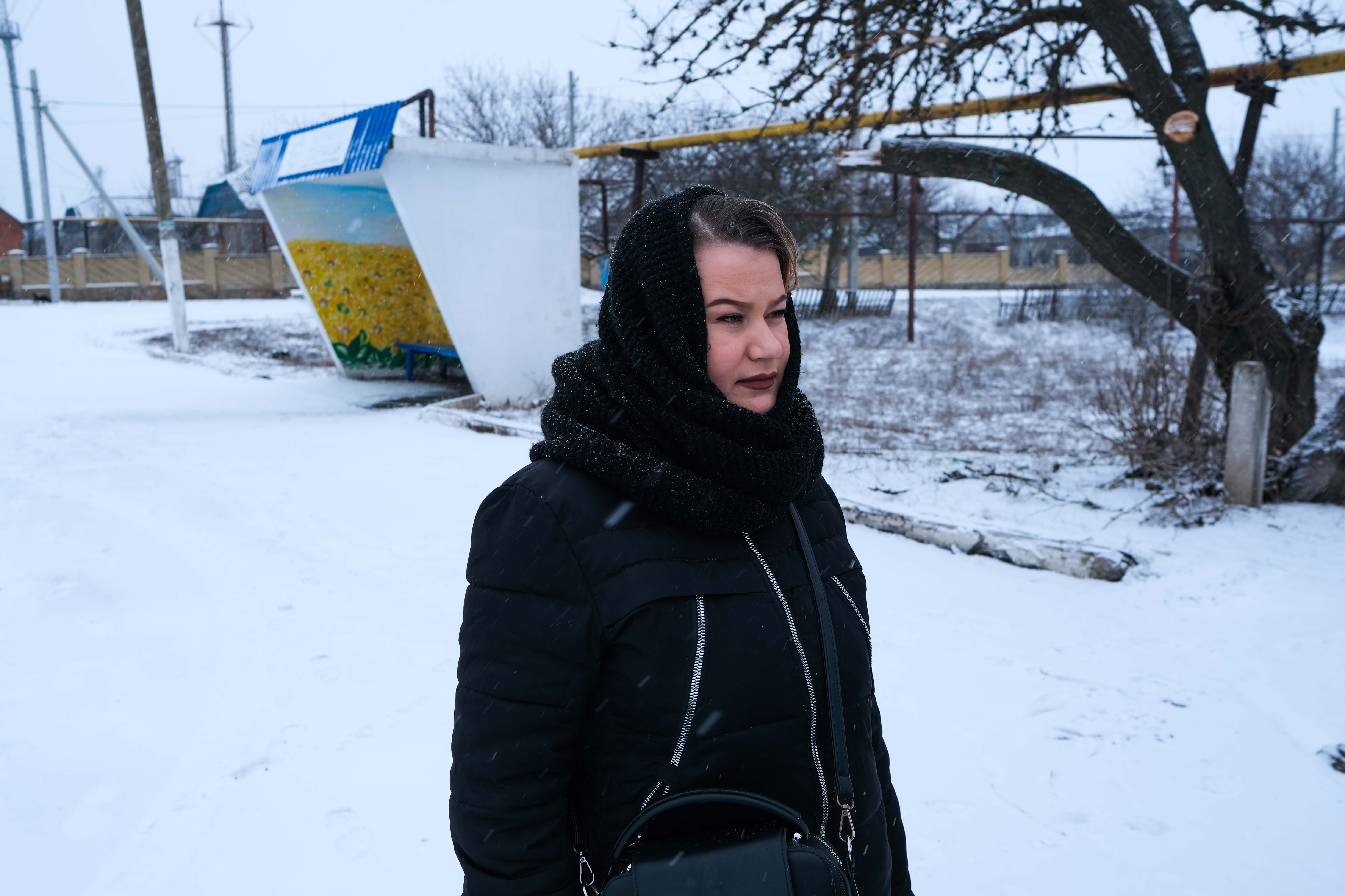 Natalya, a pensioner who lives by the riverbank, walking in the snow.
