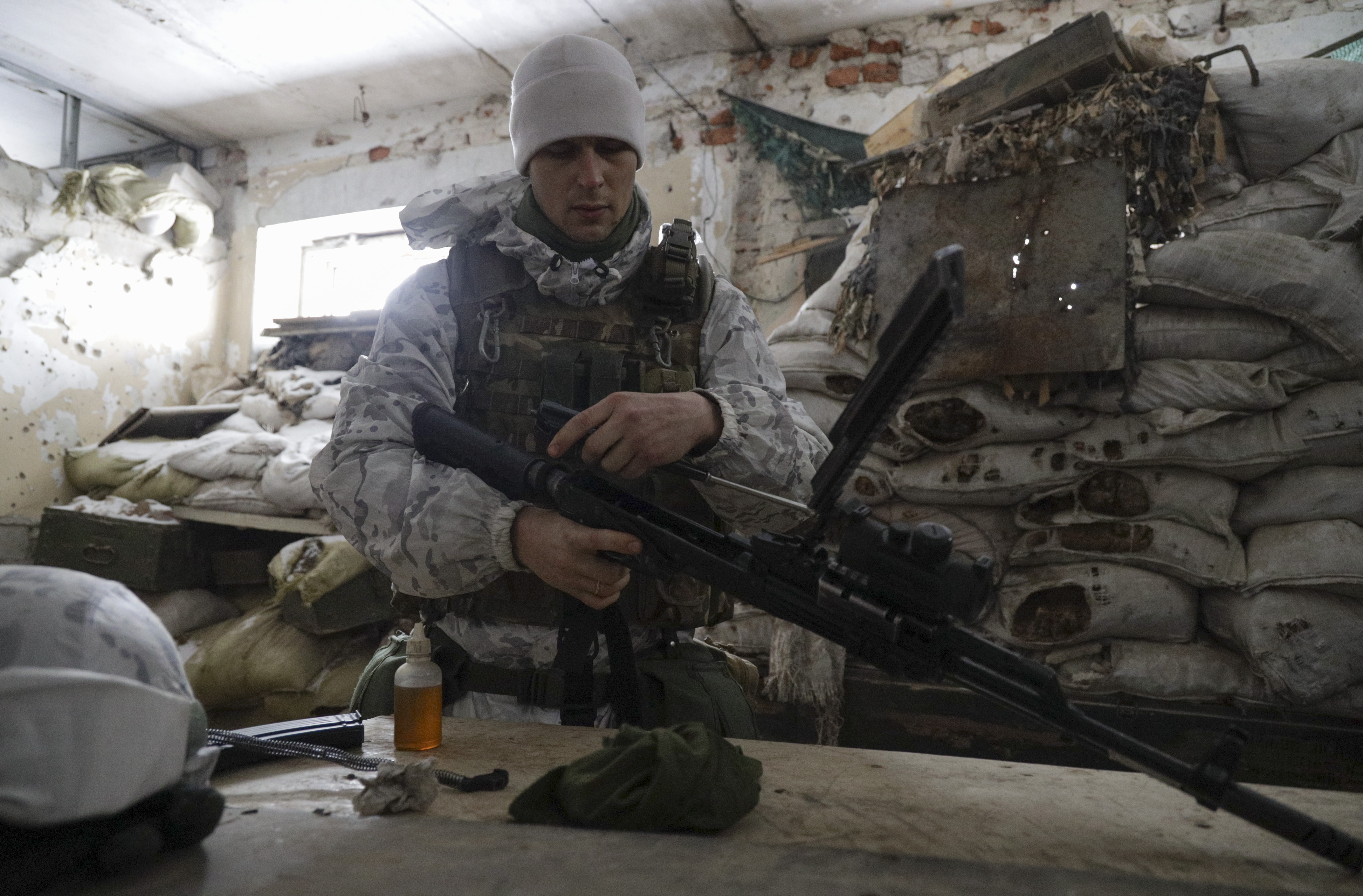 Ukrainian serviceman cleans a weapon at the positions on a front line near the Avdiivka village, not far from Donetsk, controlled by pro-Russian fighters