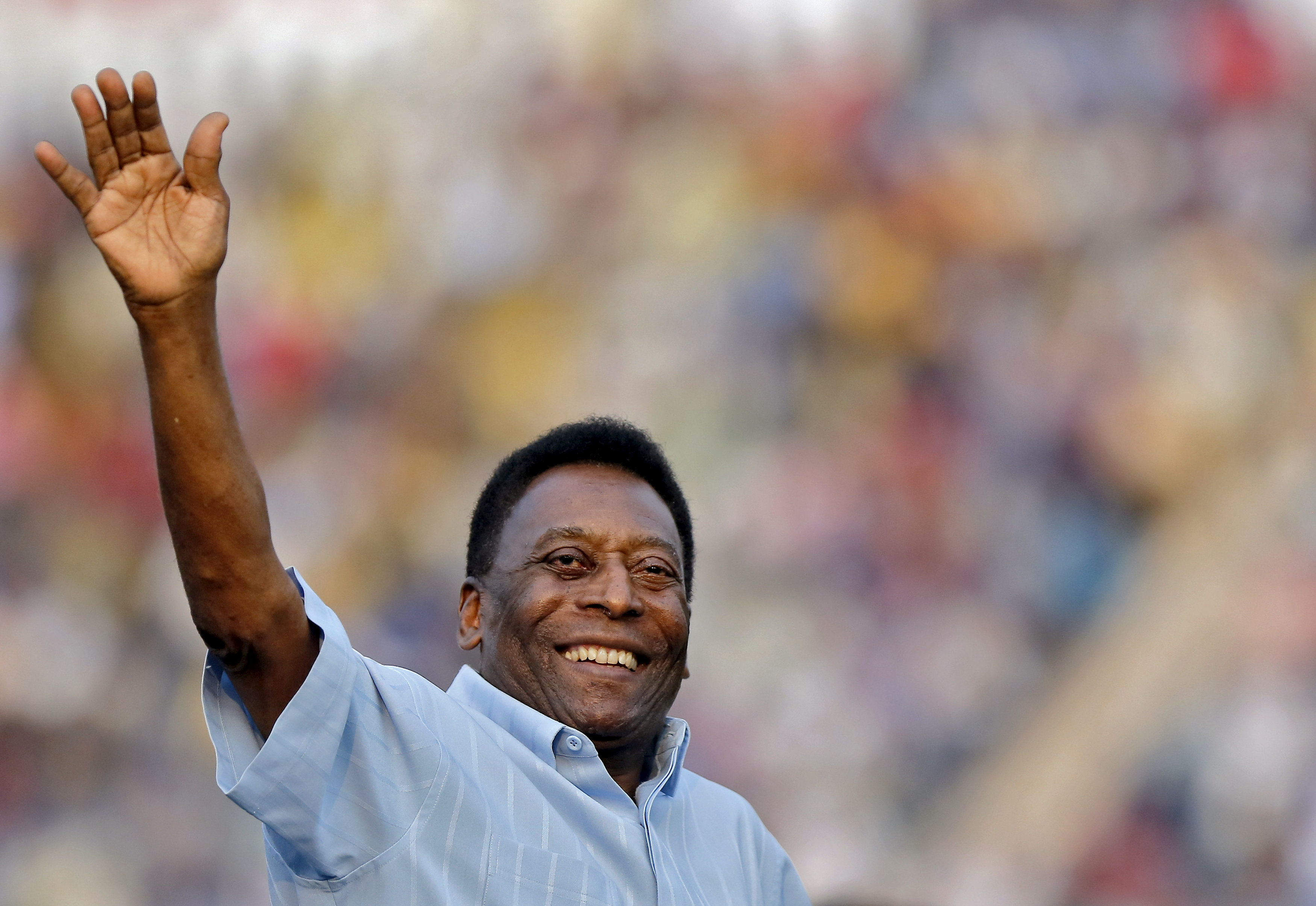 Pele waves to the spectators at Ambedkar Stadium in New Delhi, India, in 2015