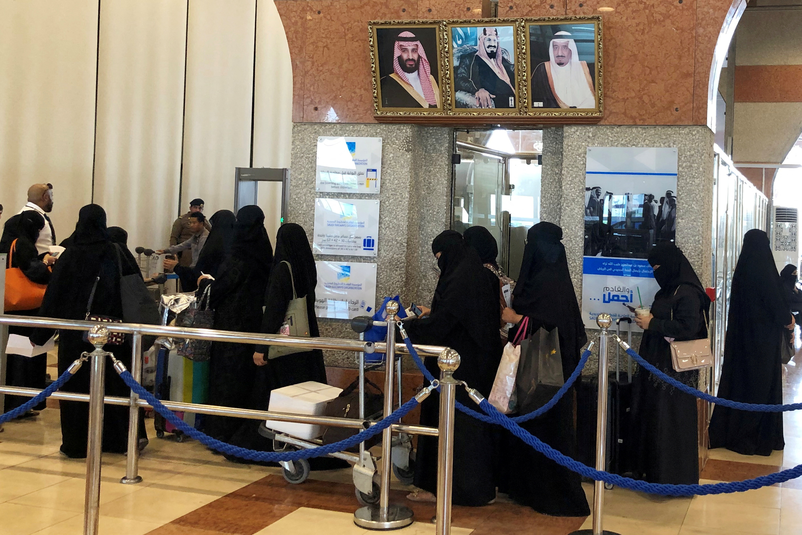 Saudi women are seen standing in line at a train station