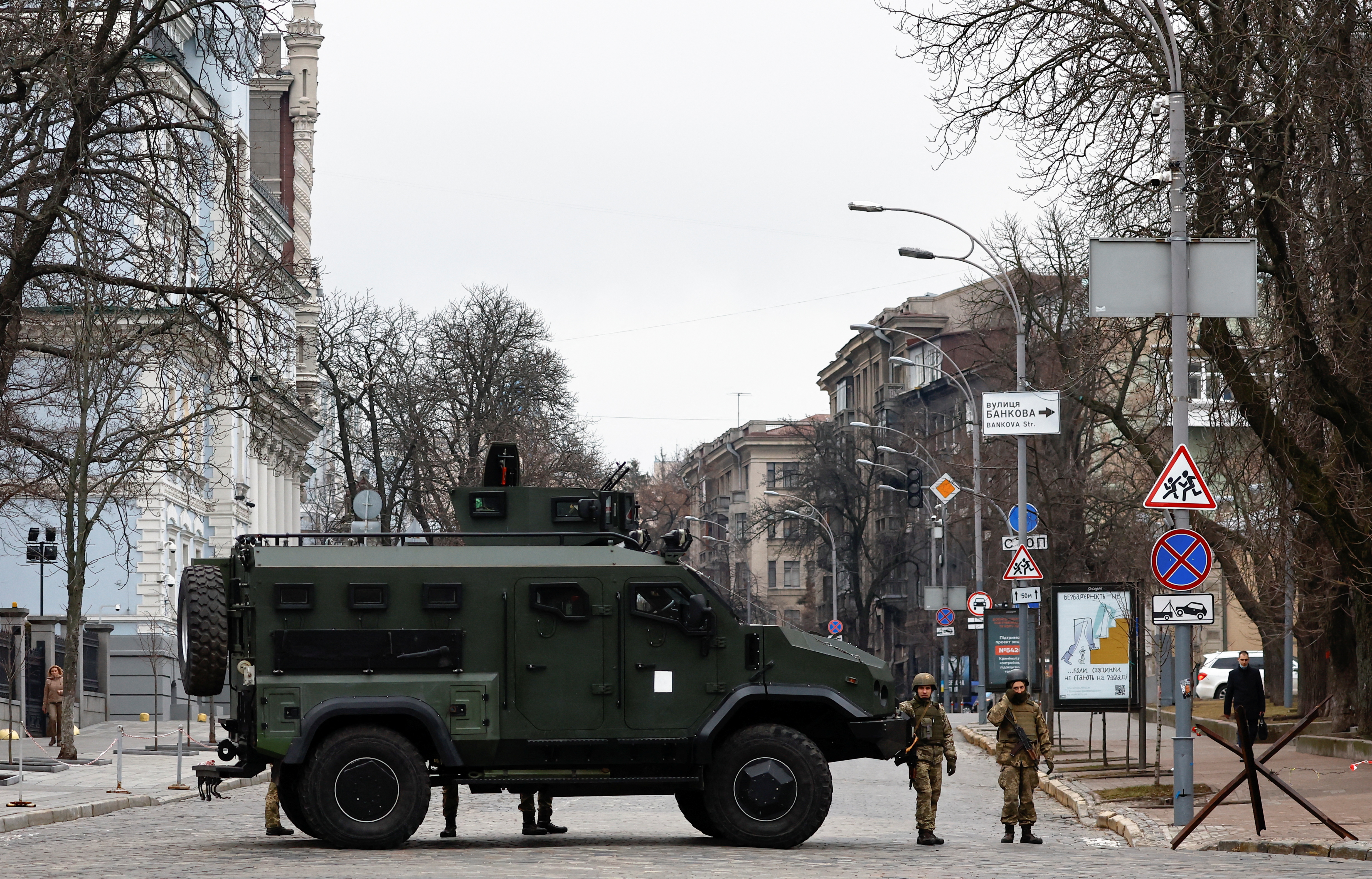 Ukrainian military service members guard a road that leads to a government block, after Russia attacked Ukraine, in Kyiv, Ukraine, February 24