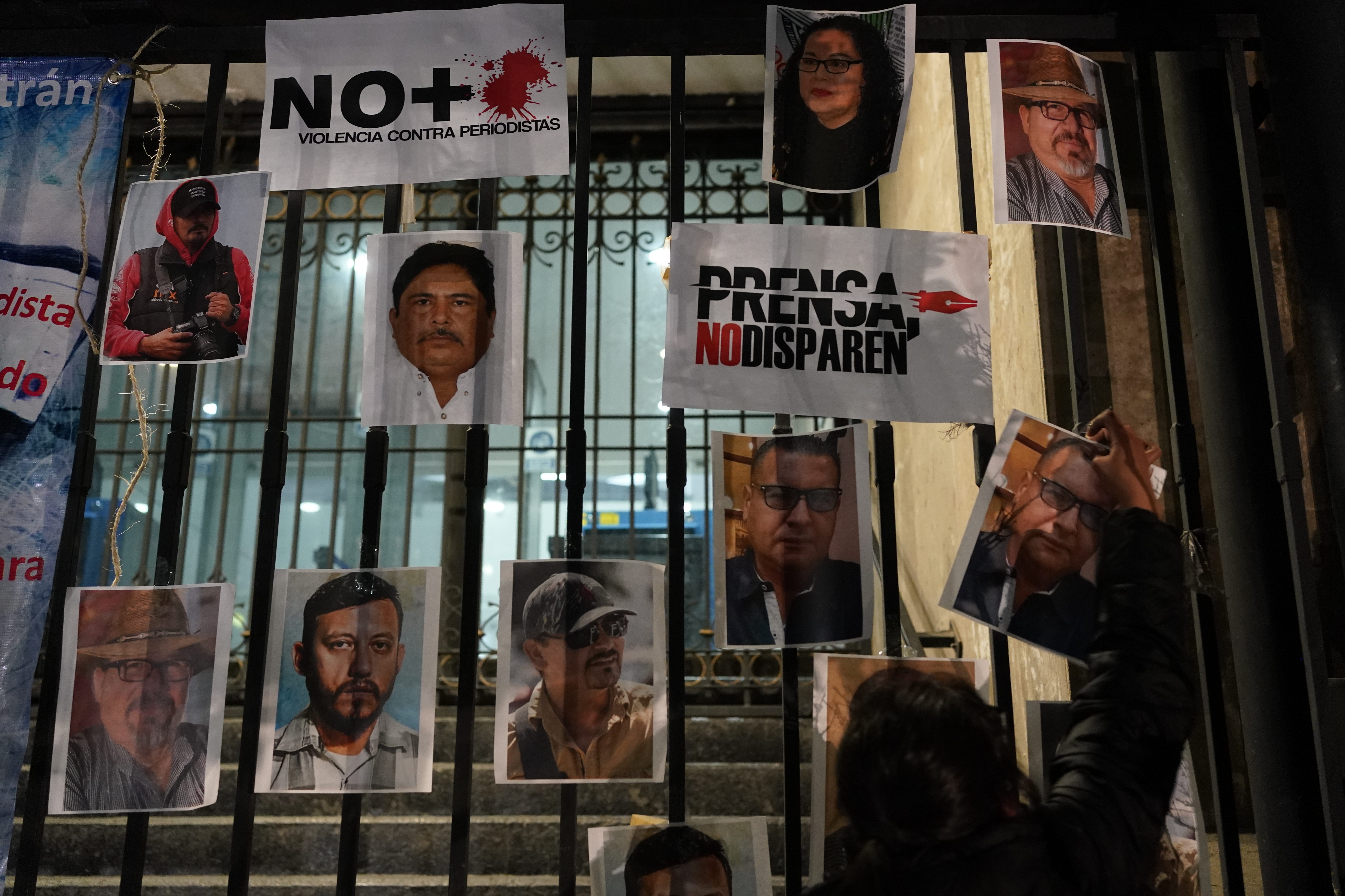 A woman posts photos of murdered journalists during a national protest against the murder of journalists