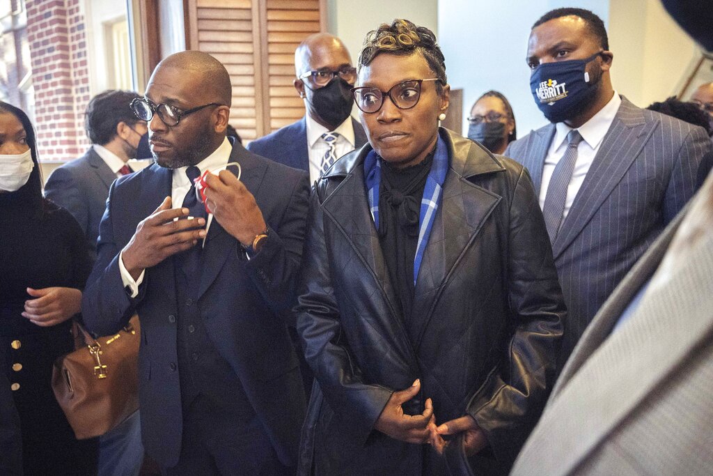 Ahmaud Arbery's mother Wanda Cooper-Jones, center, is surrounded by supporters after Superior Court Judge Timothy Walmsley sentenced Greg McMichael, his son, Travis McMichael, and a neighbor, William "Roddie" Bryan to life in prison.