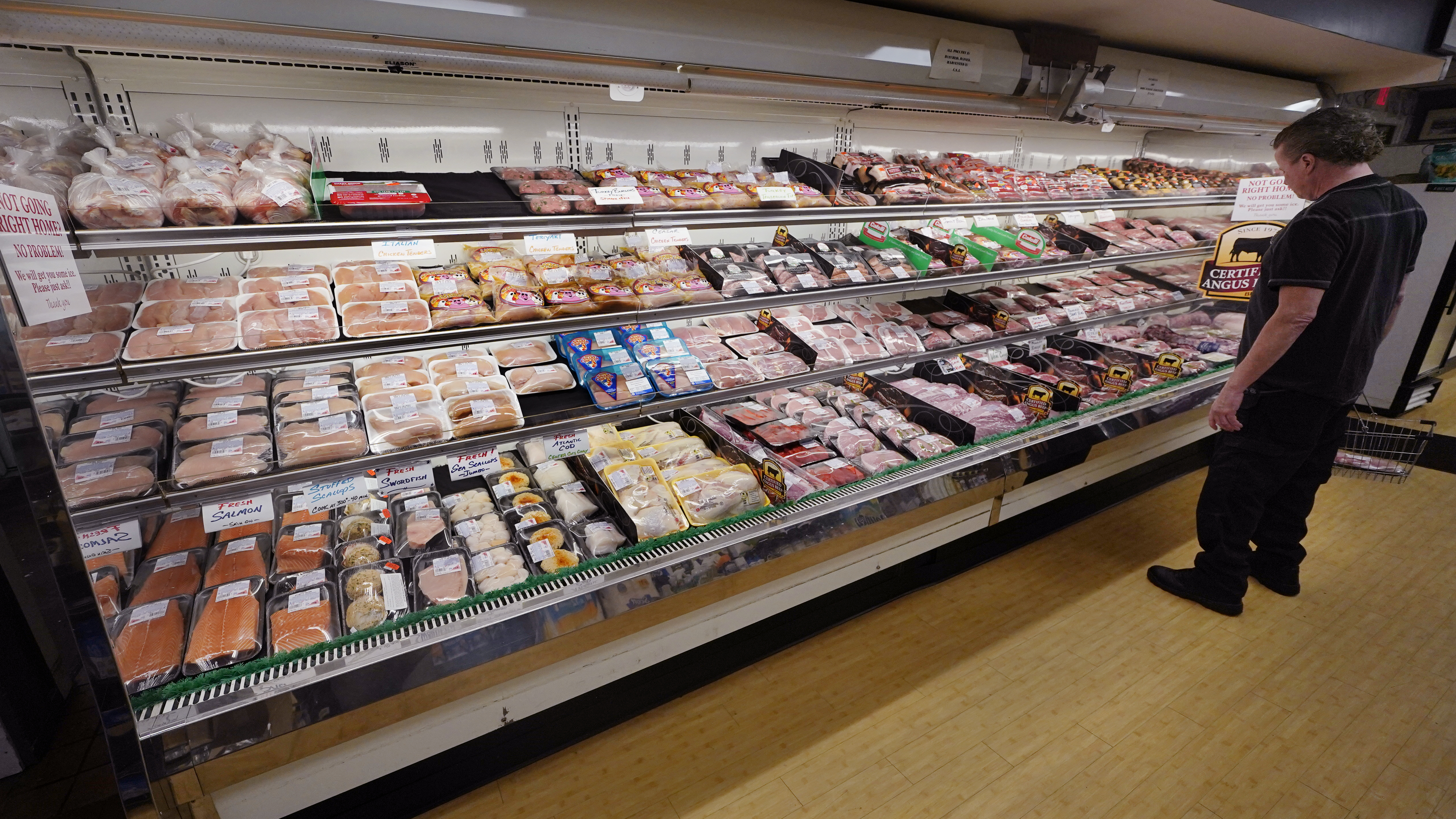 A man looks at beef in the meat department of a supermarket