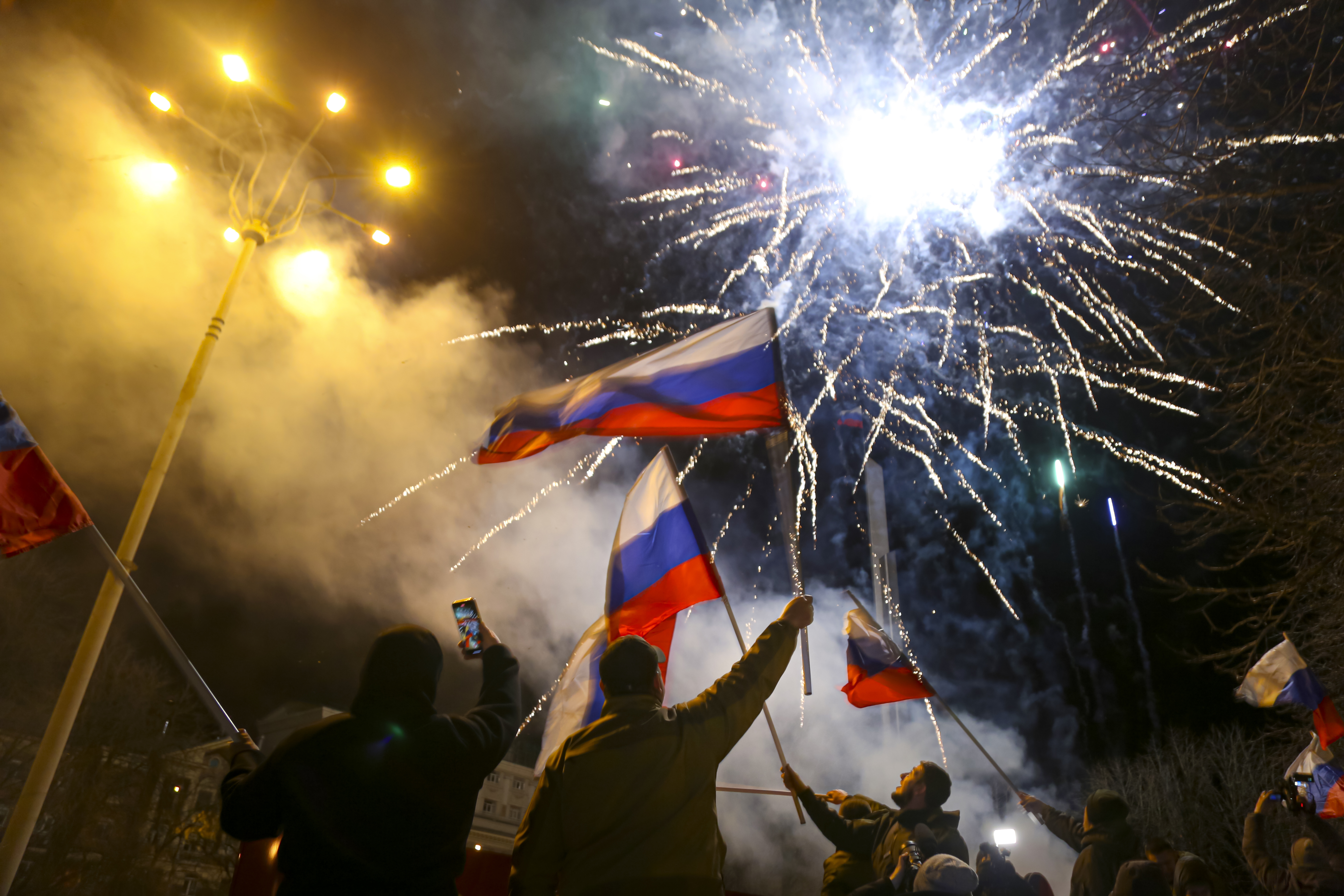 People wave Russian flags celebrating the recognition of their independence in the centre of Donetsk, the territory controlled by pro-Russian fighters in eastern Ukraine