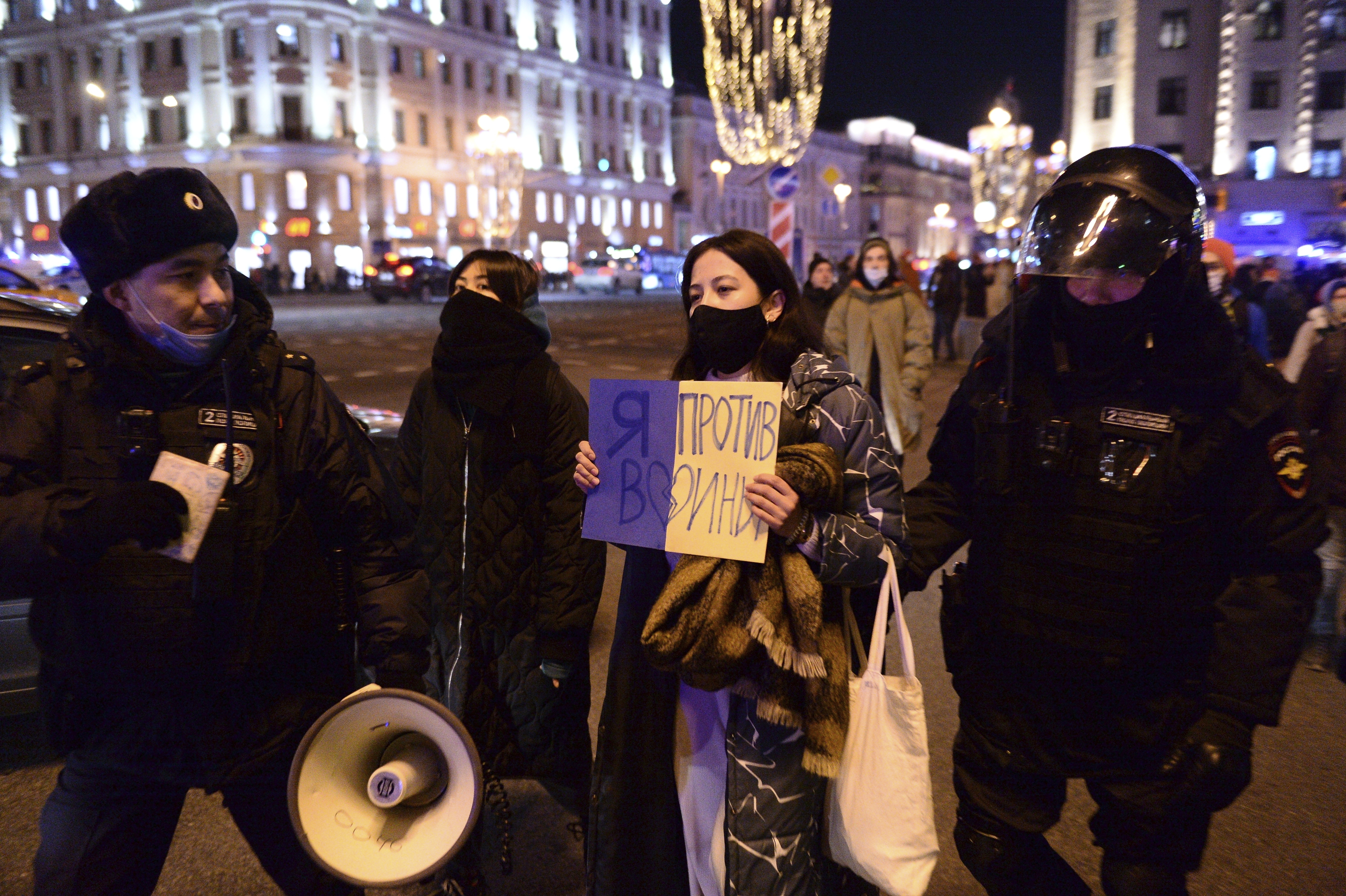 Police officers detain a demonstrator holding a sign reading: ‘I’m against the war’ in Moscow, Russia, February 24, 2022