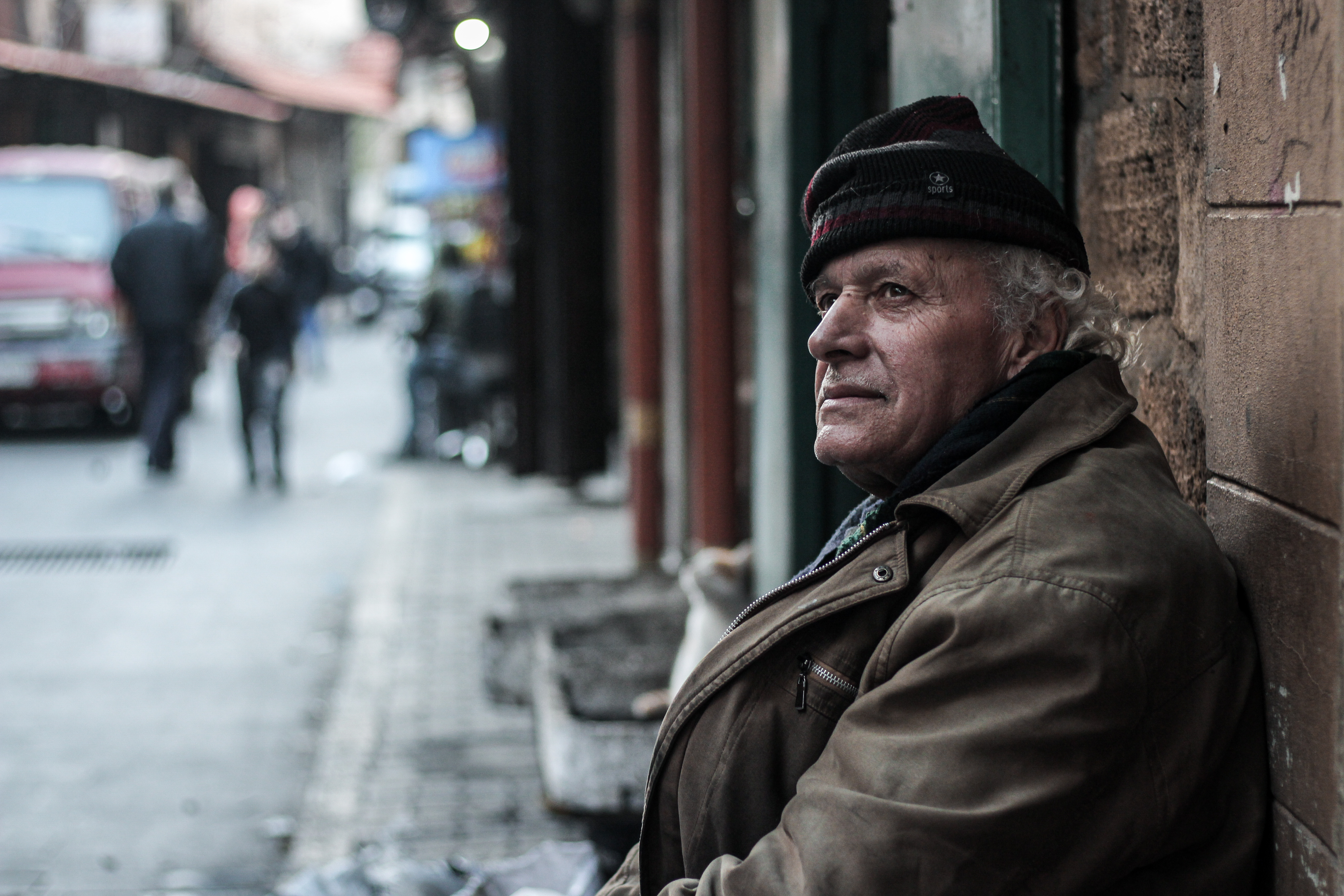 A man sits on the pavement of a street in Tripoli.
