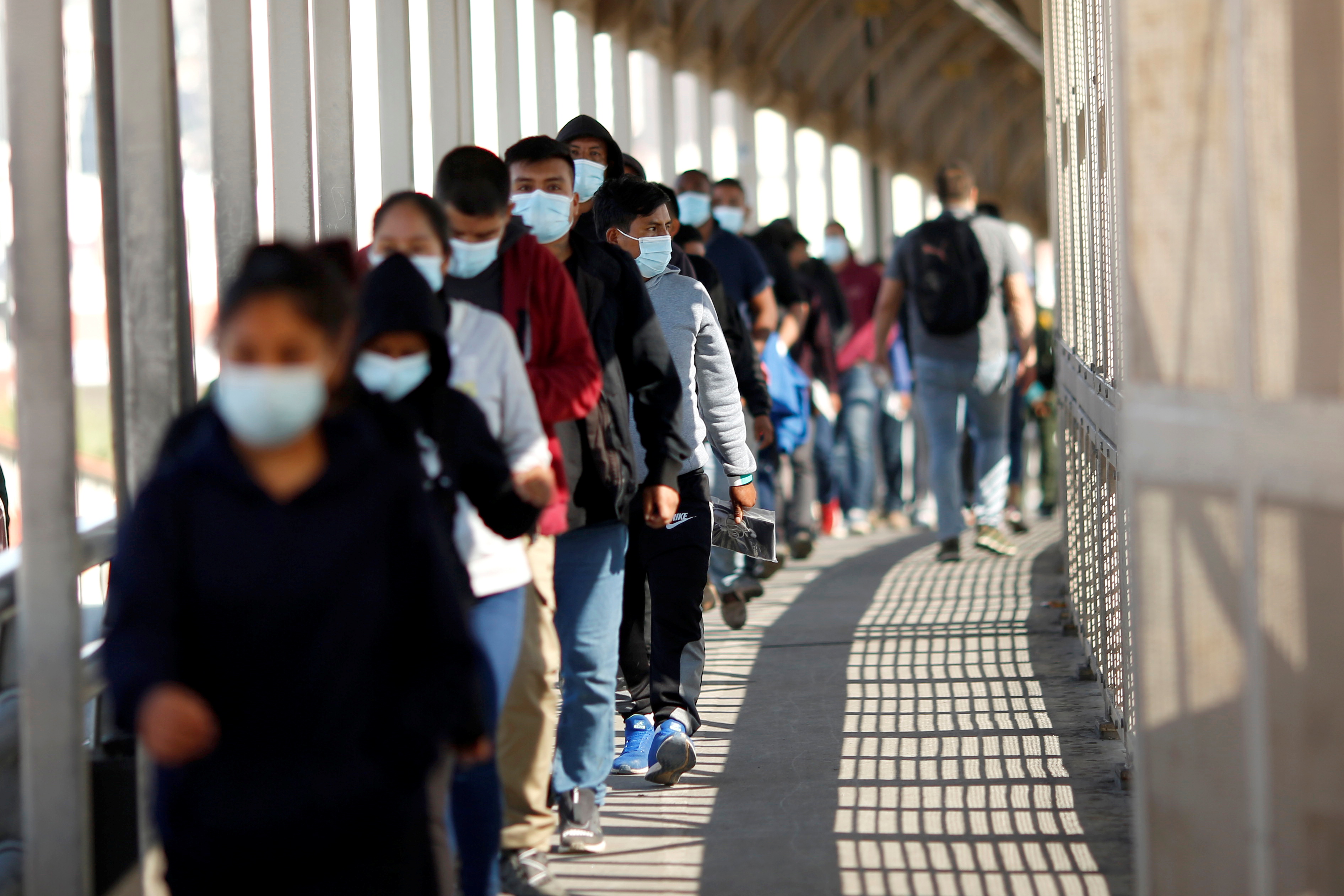 Asylum seekers expelled from US stand in a line