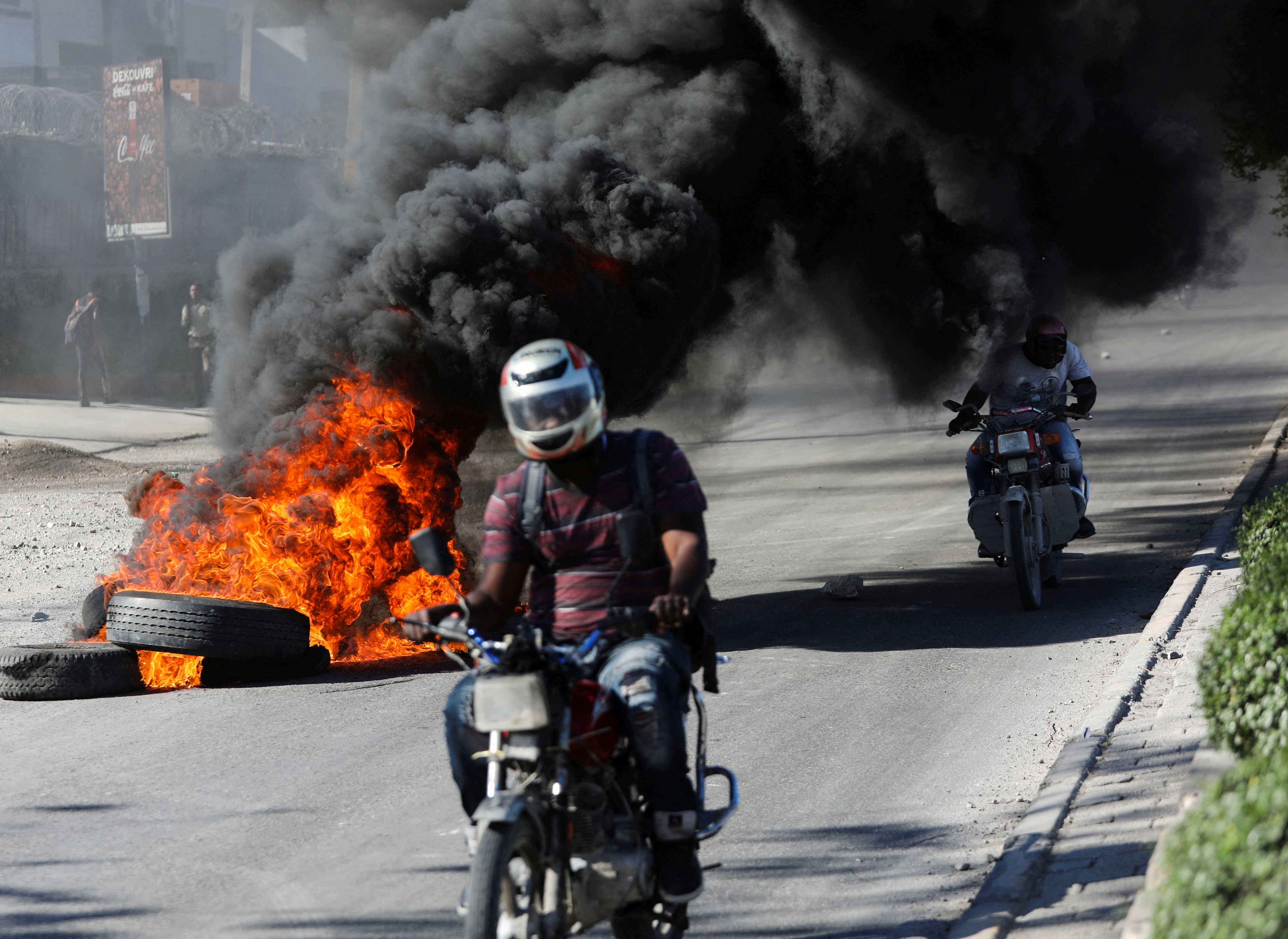 Motorcycle driving past burning tire