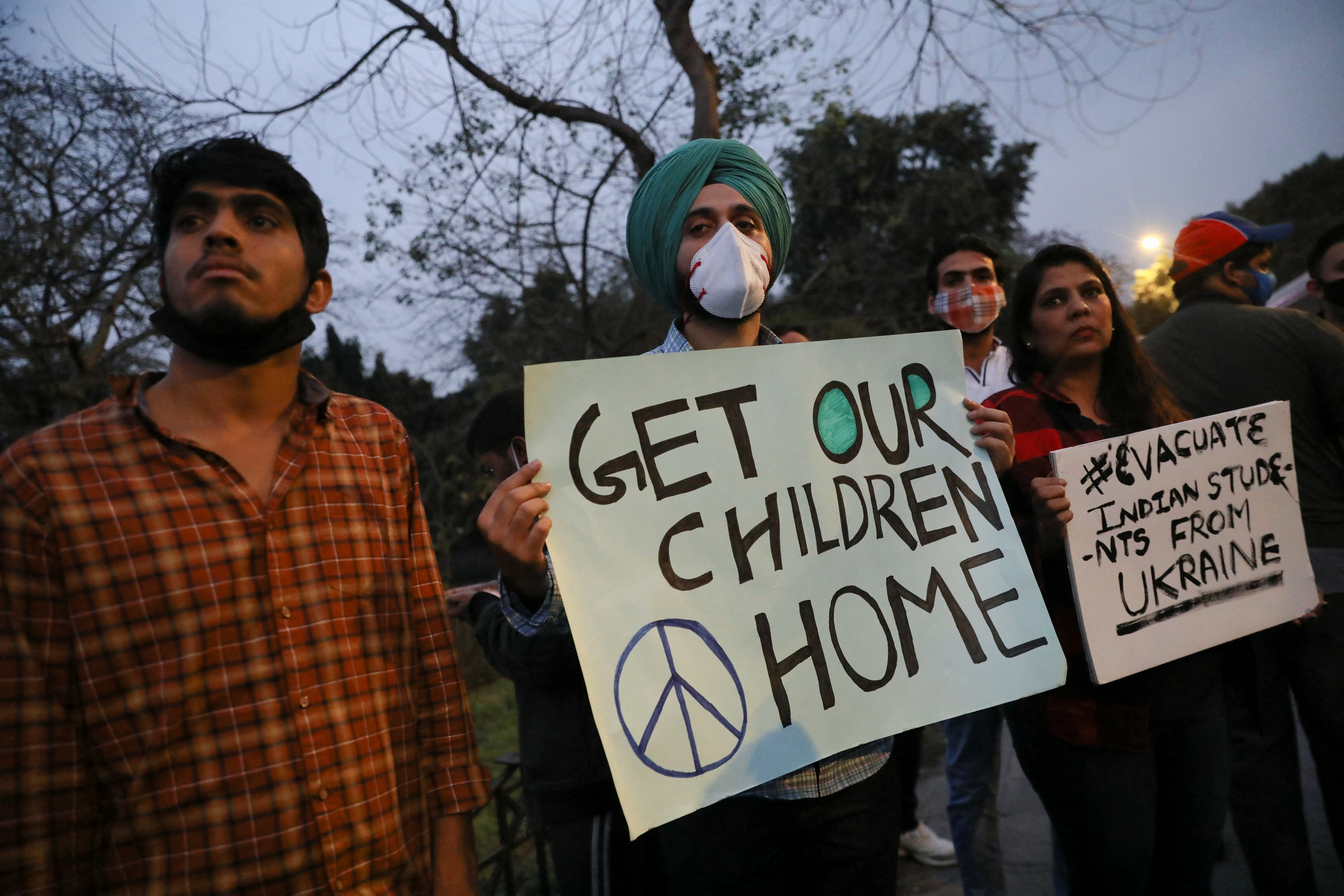 Family and friends of Indian students stuck in Ukraine hold placards, as they demand the Indian government to evacuate the stranded students, near the Russian embassy in New Delhi