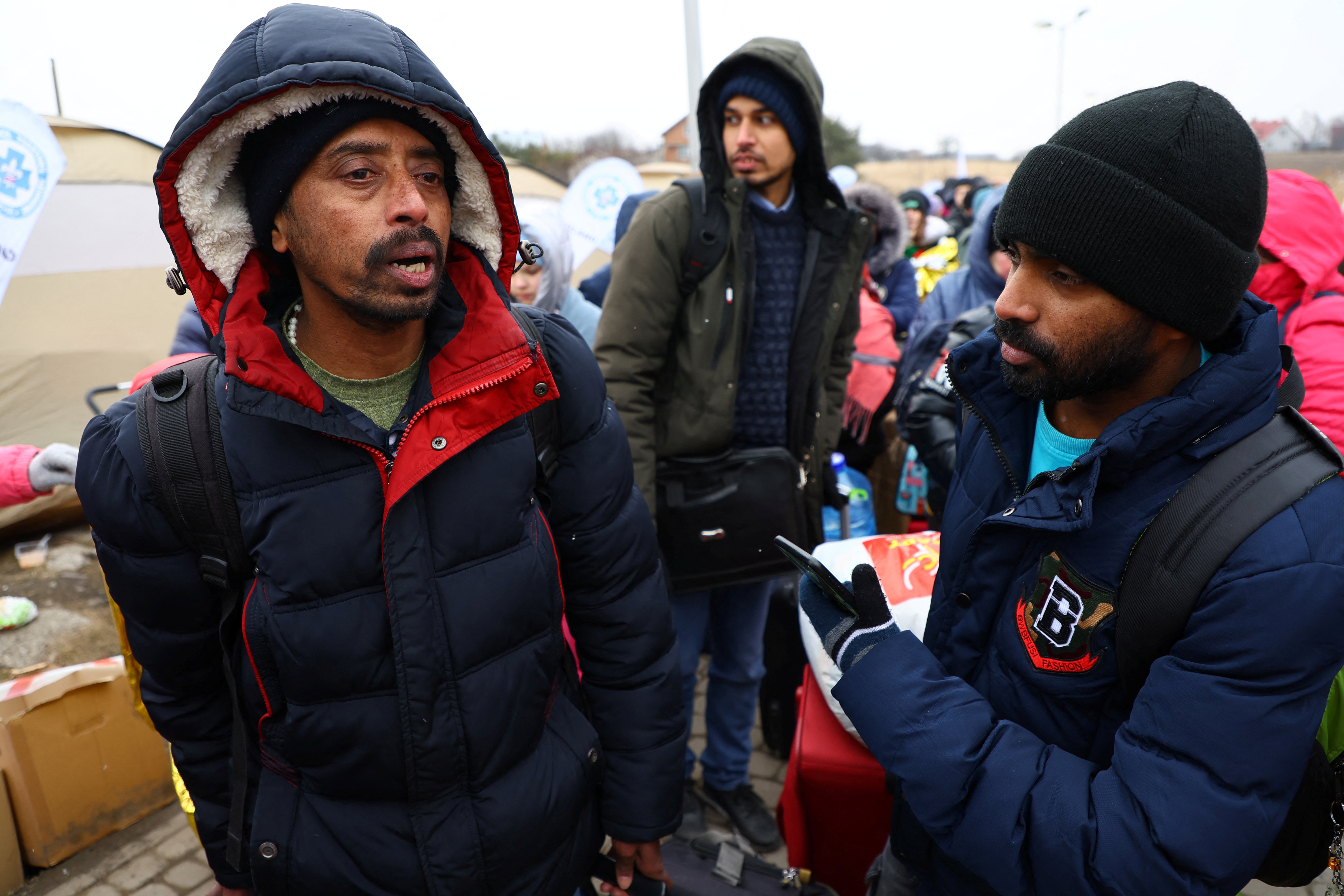 Indians working in Kyiv wait to board a bus after crossing the border to Poland