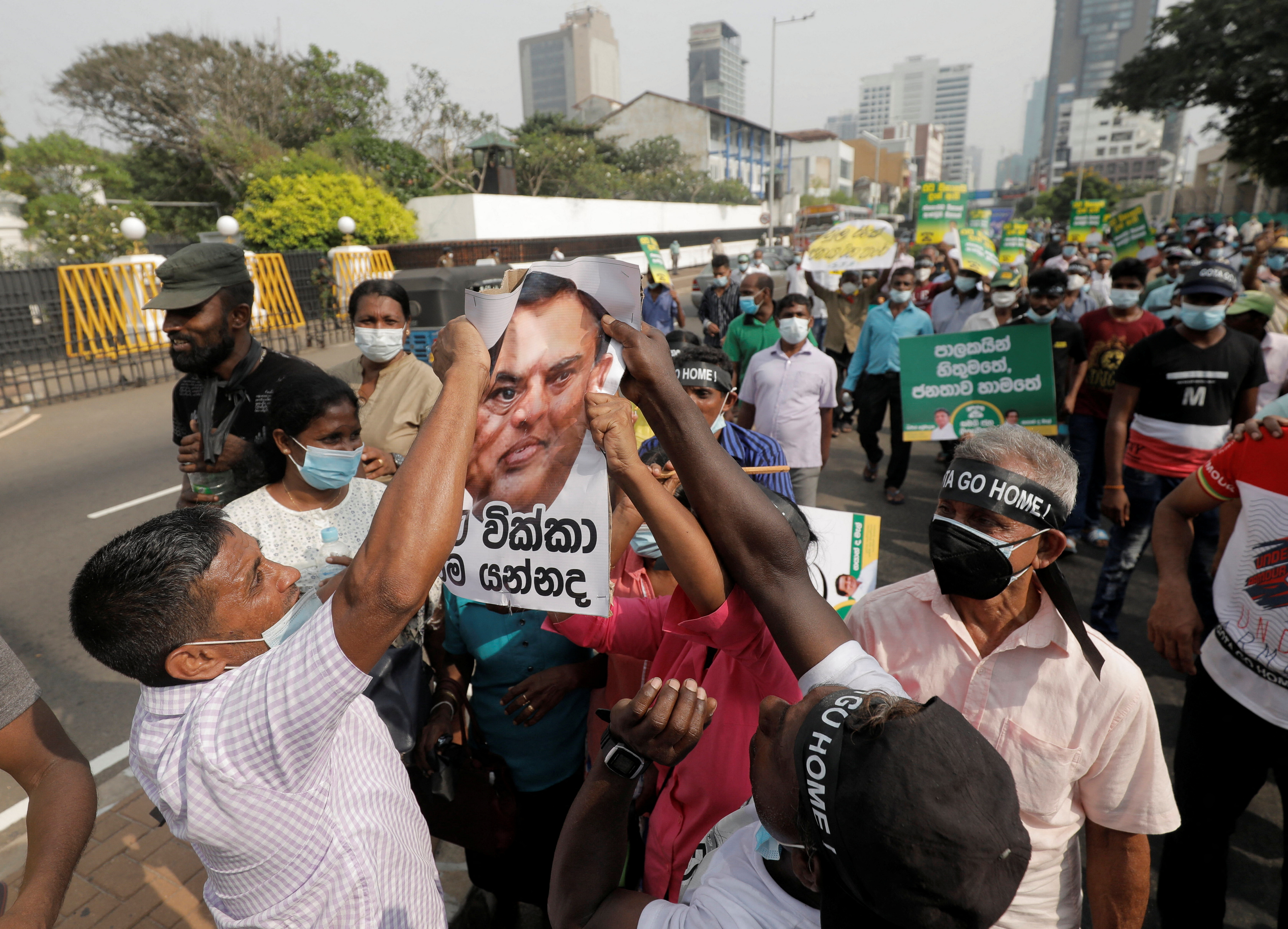 People hold a picture of Finance Minister Basil Rajapaksa during the protest in Colombo