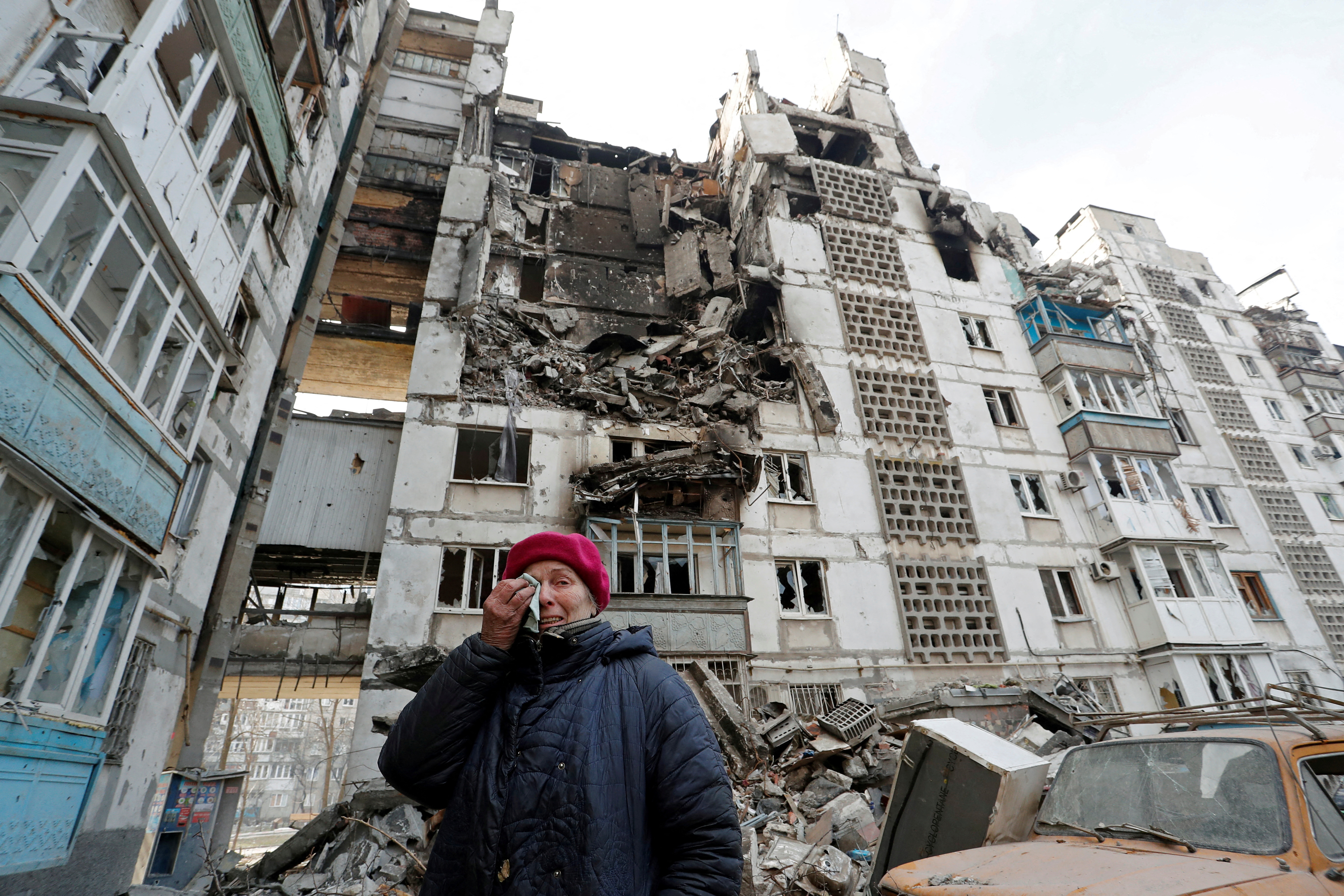 Local resident Valentina Demura, 70, reacts next to the building where her apartment, destroyed during Ukraine-Russia conflict, is located in the besieged southern port city of Mariupol, Ukraine March 27, 2022.