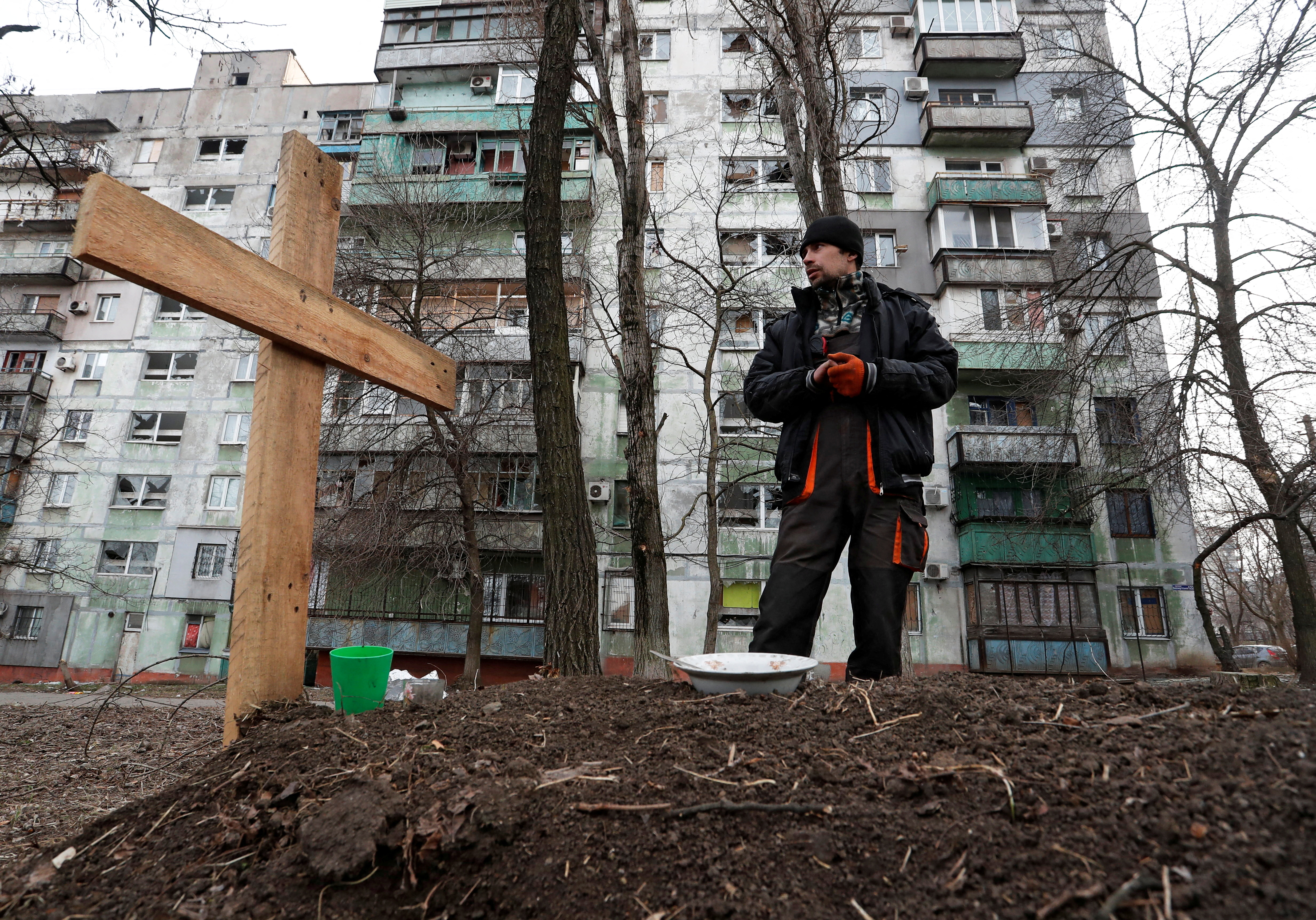 Local resident Pavel, 42, stands next to the grave of his friend Igor in a residential area of the besieged southern port city of Mariupol