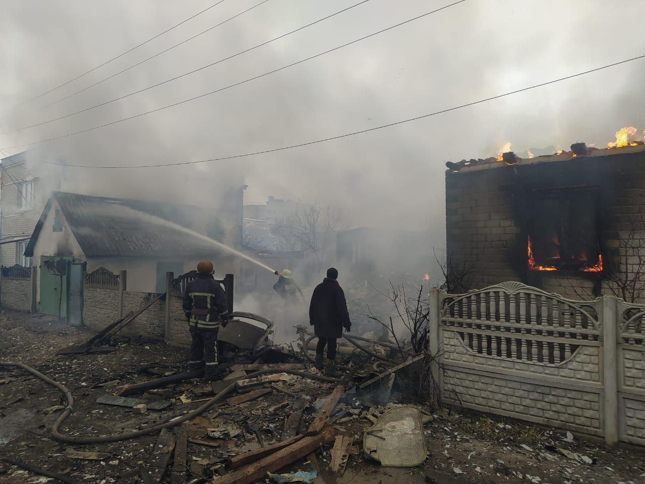A photo of firefighters extinguishing the fire of a house.