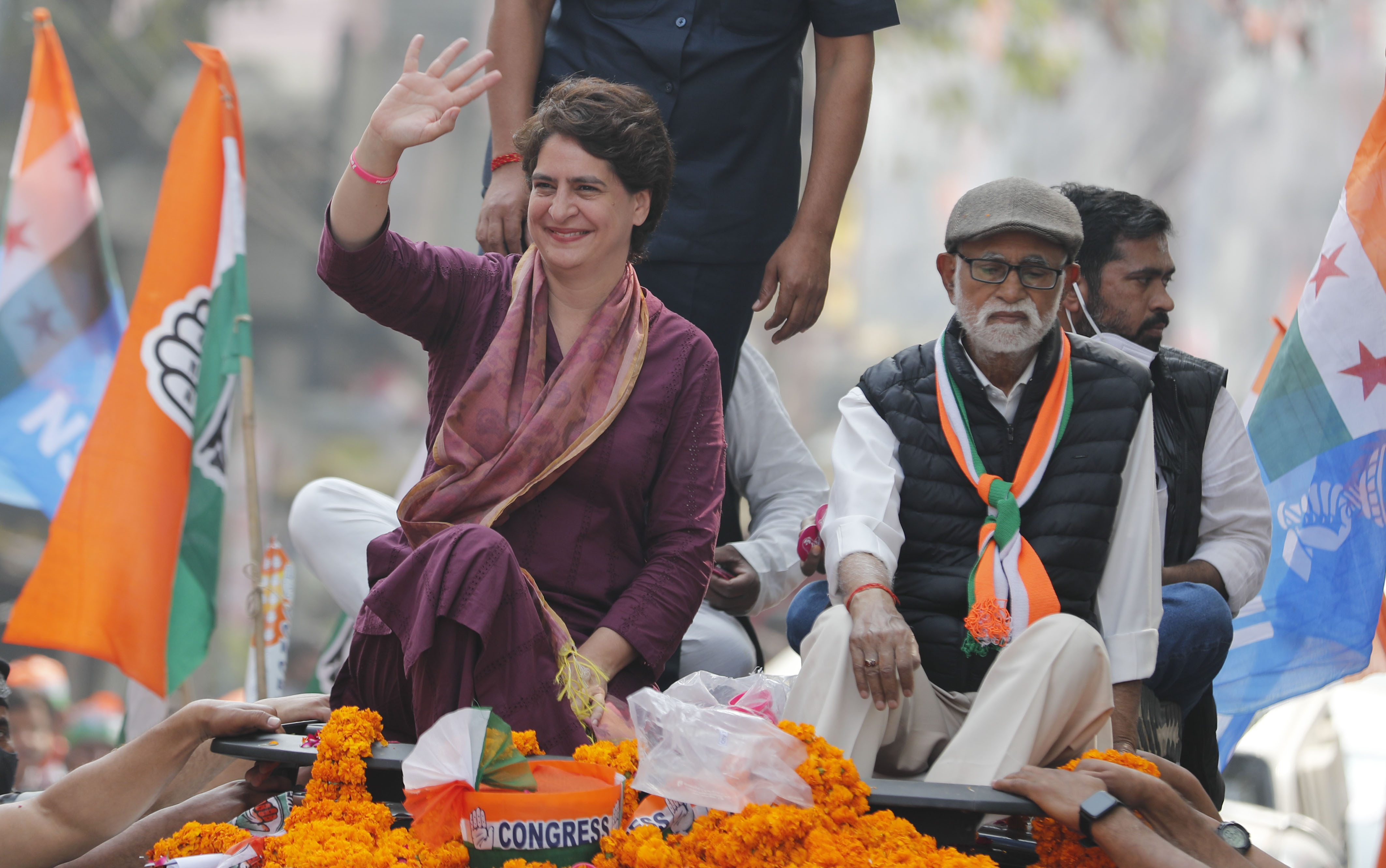 Priyanka Gandhi, left, waves during a roadshow for assembly elections in Uttar Pradesh
