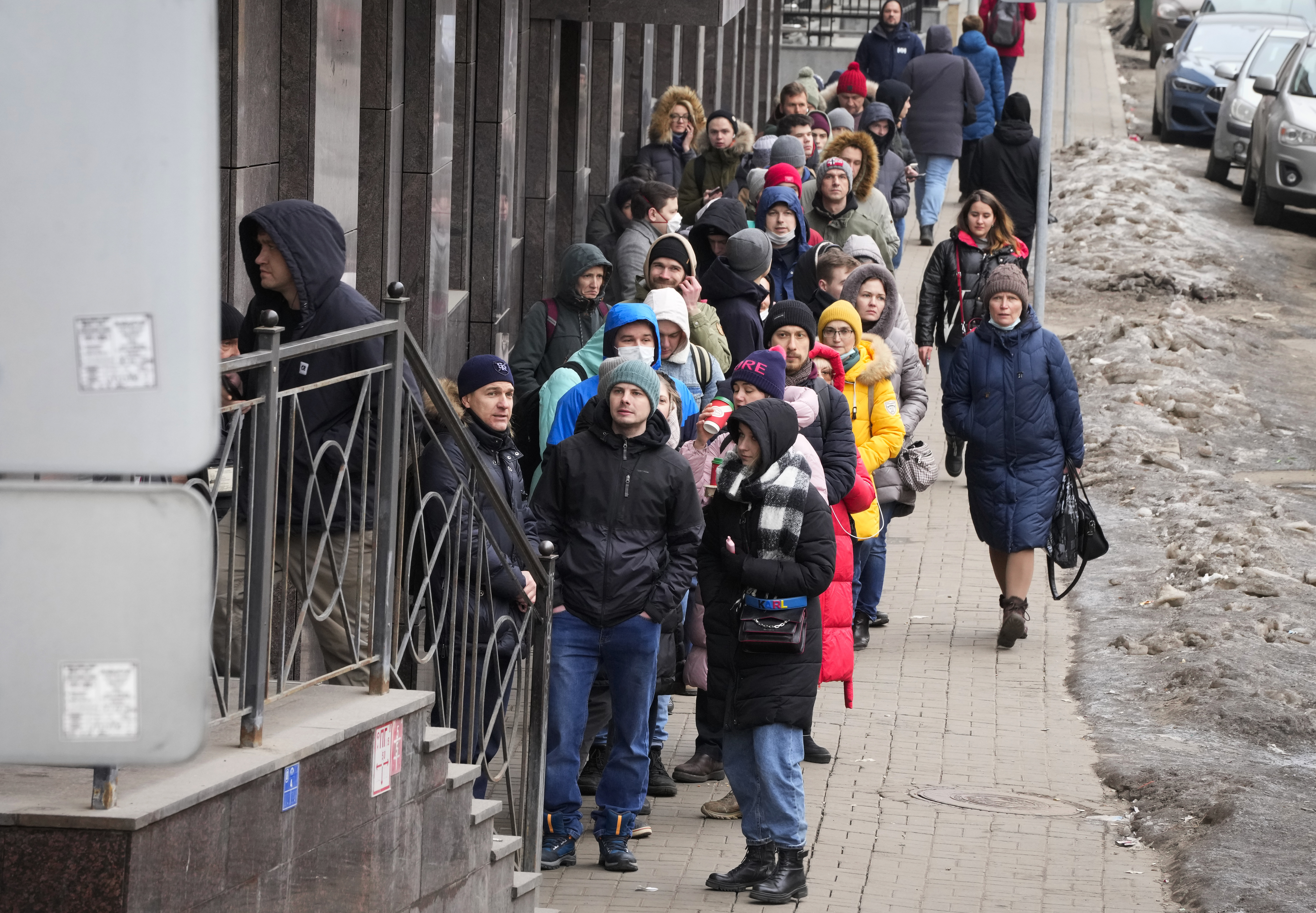 People stand in line to withdraw U.S. dollars and Euros from an ATM in St. Petersburg, Russia, Friday, Feb. 25, 2022. Ordinary Russians faced the prospect of higher prices and crimped foreign travel as Western