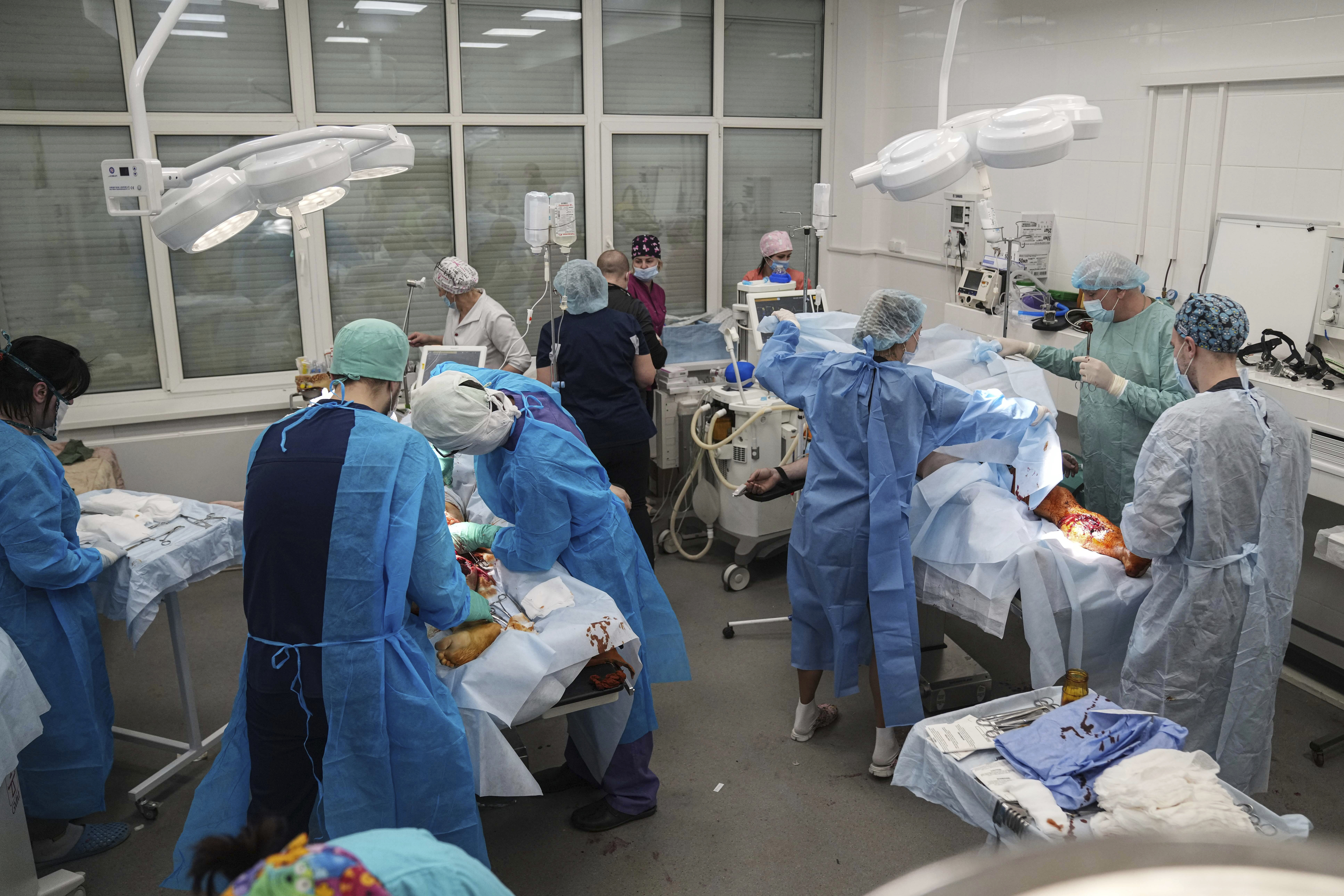 Medical workers operate on people injured by shelling in a residential area at a maternity hospital converted into a medical ward in Mariupol, Ukraine