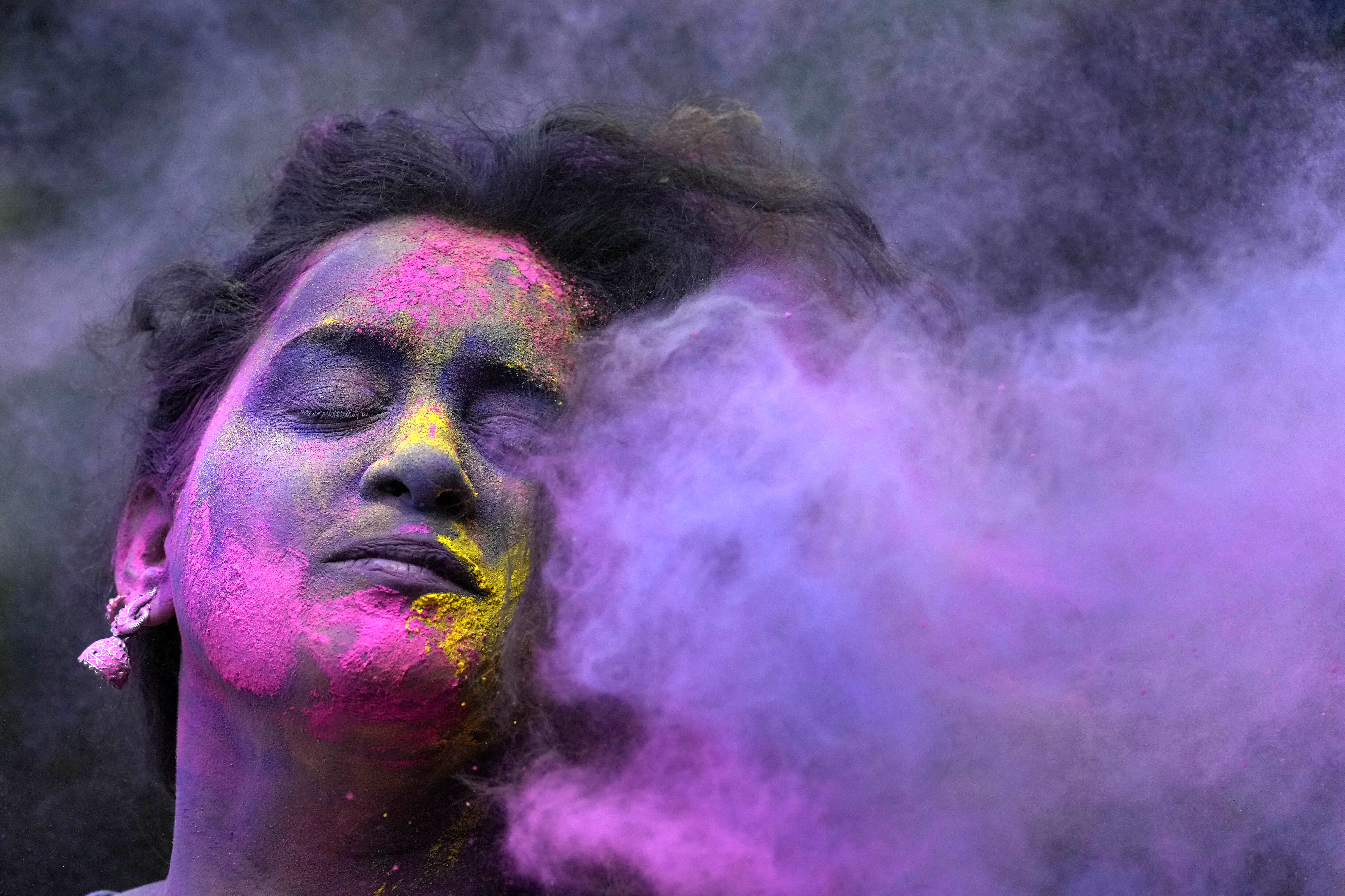 A woman smeared with colours play Holi, the Hindu festival of colours, in Mumbai, India