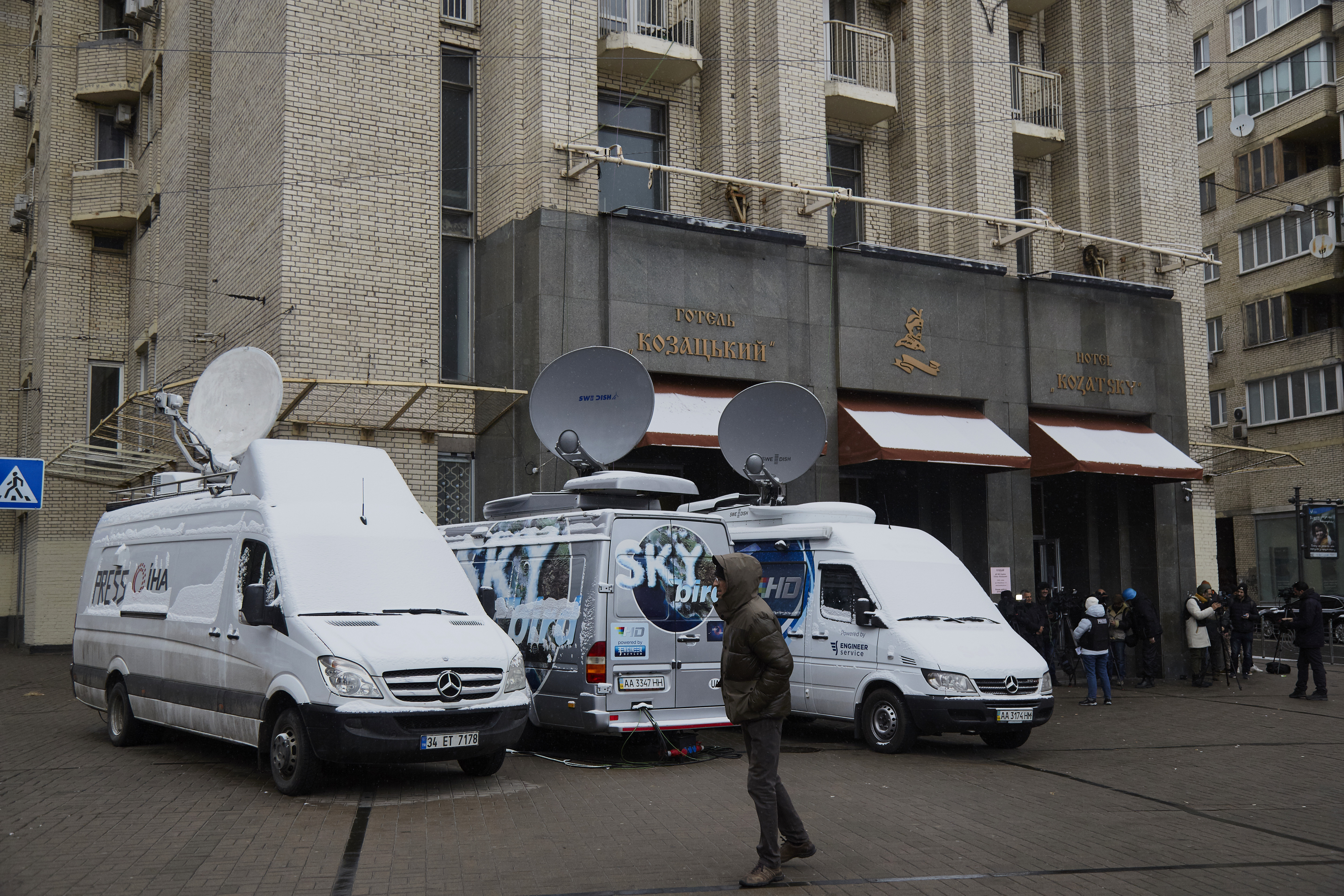 White media vans with satellites and journalists are seen outside a hotel in Kyiv, Ukraine