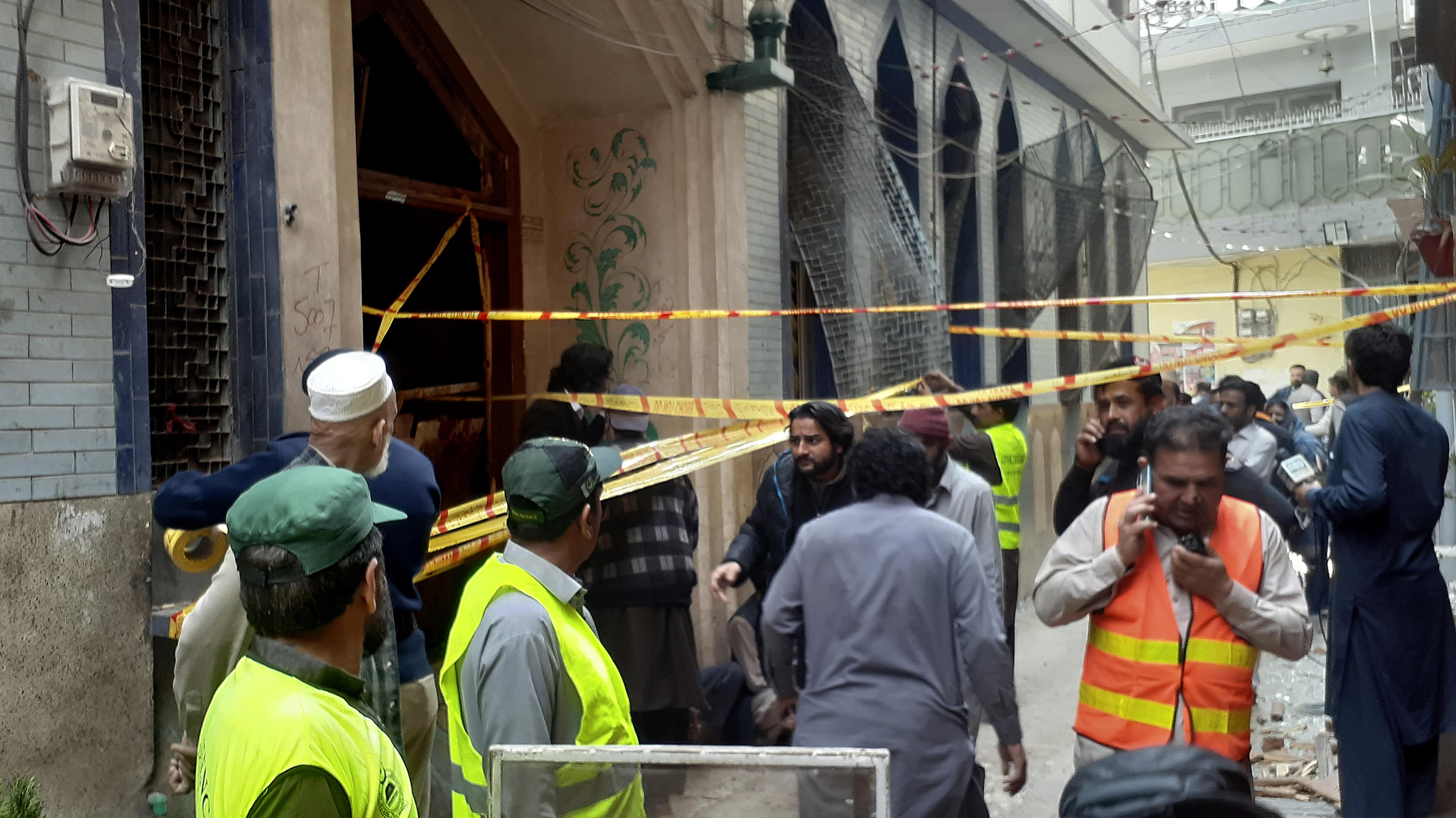 Rescue workers and volunteers gather at the site of bomb explosion in Peshawar