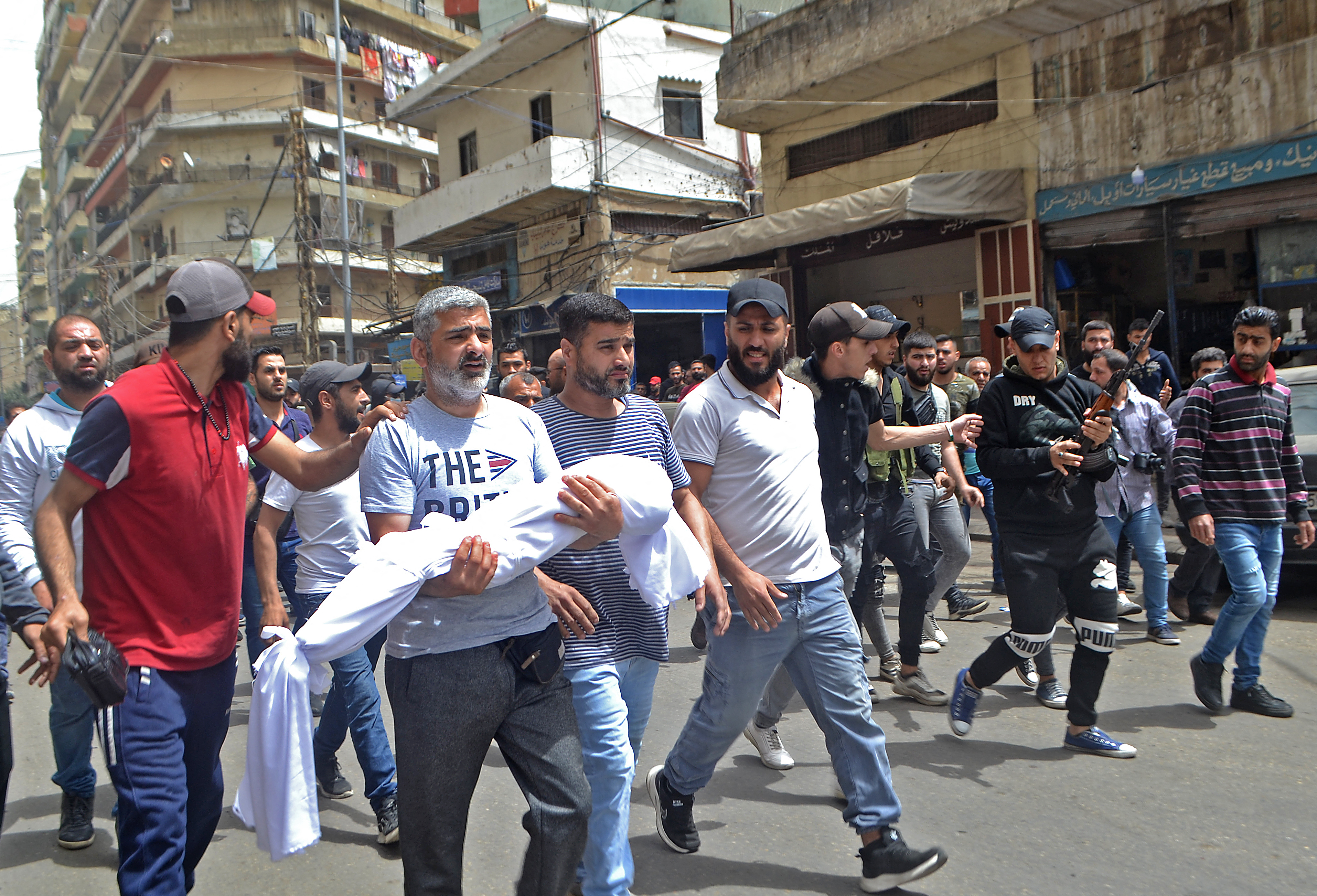 Mourners carry the body of a child, killed after a boat loaded with migrants capsized near the coast of the northern city of Tripoli, during a funeral in the northern Lebanese city on April 25, 2022. Lebanon searched for survivors after rescuing 45 people and retrieving the corpse of a child from a capsized boat in the eastern Mediterranean loaded with dozens of migrants.