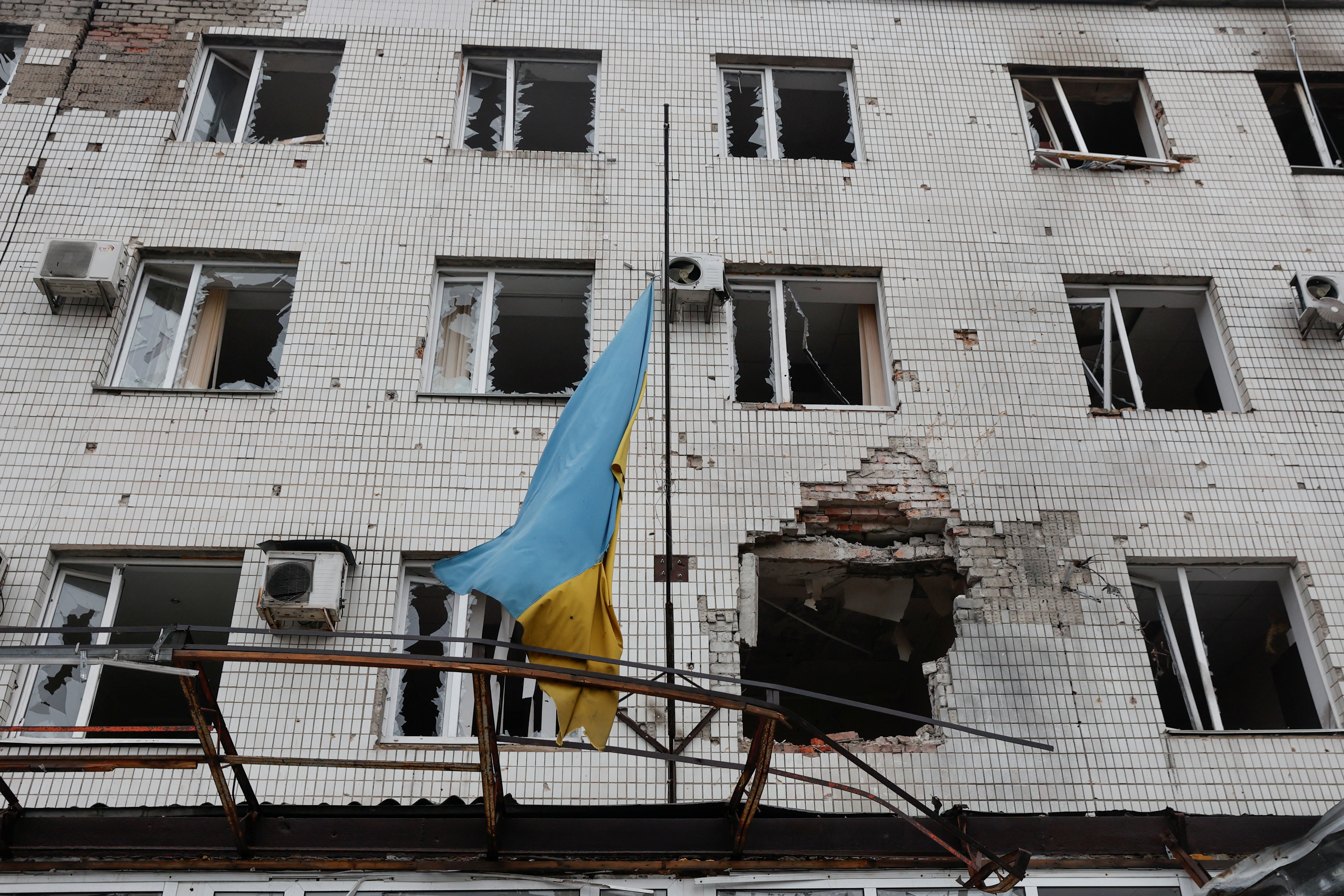A Ukrainian national flag flutters on an administrative building damaged by shelling, as Russia’s attack on Ukraine continues, in the town of Marinka, in Donetsk region