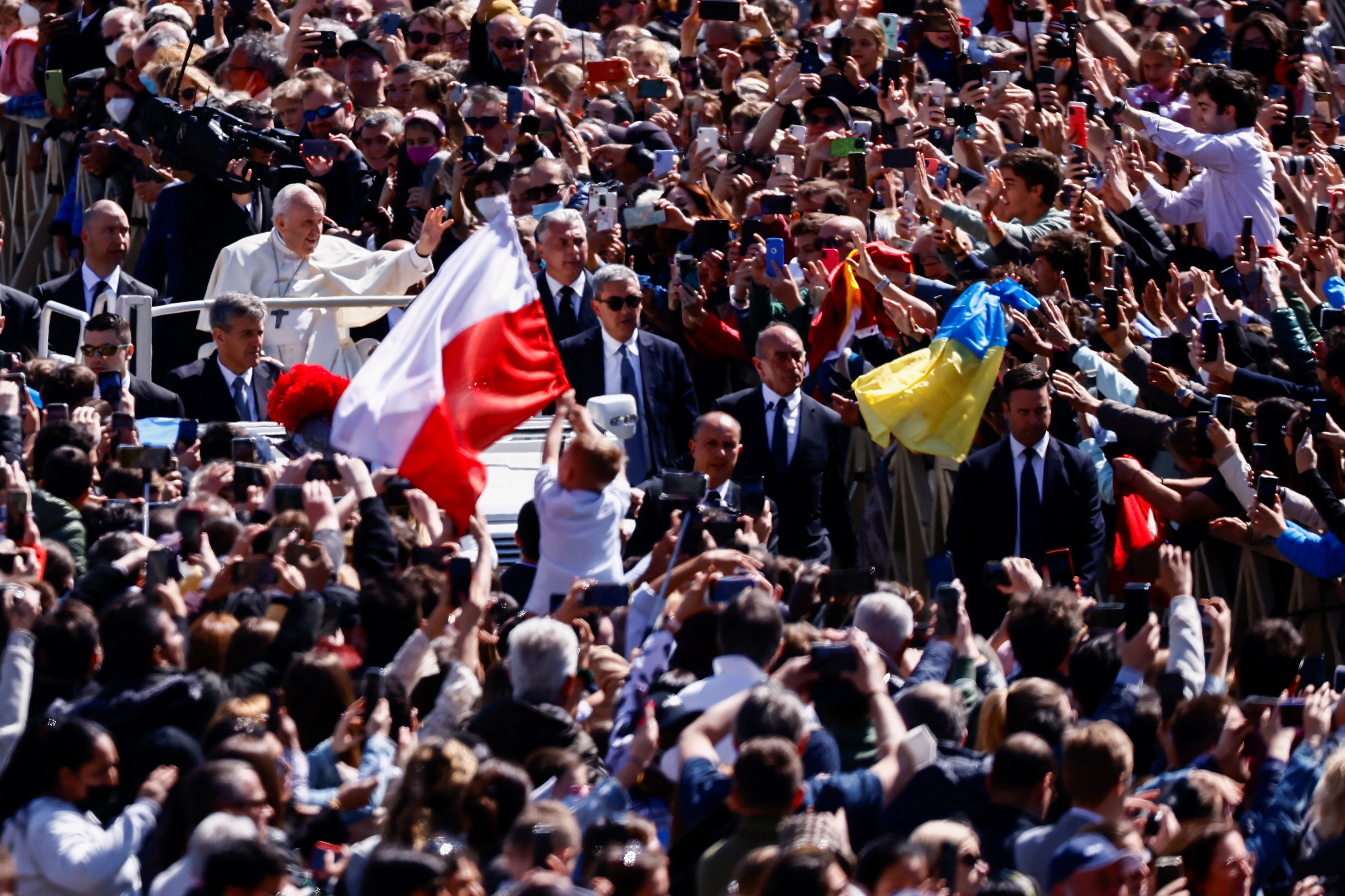 Polish and Ukrainian flags wave among the crowd as Pope Francis greets the faithful from his Popemobile in Saint Peter’s Square, after celebrating Easter Mass at the Vatican