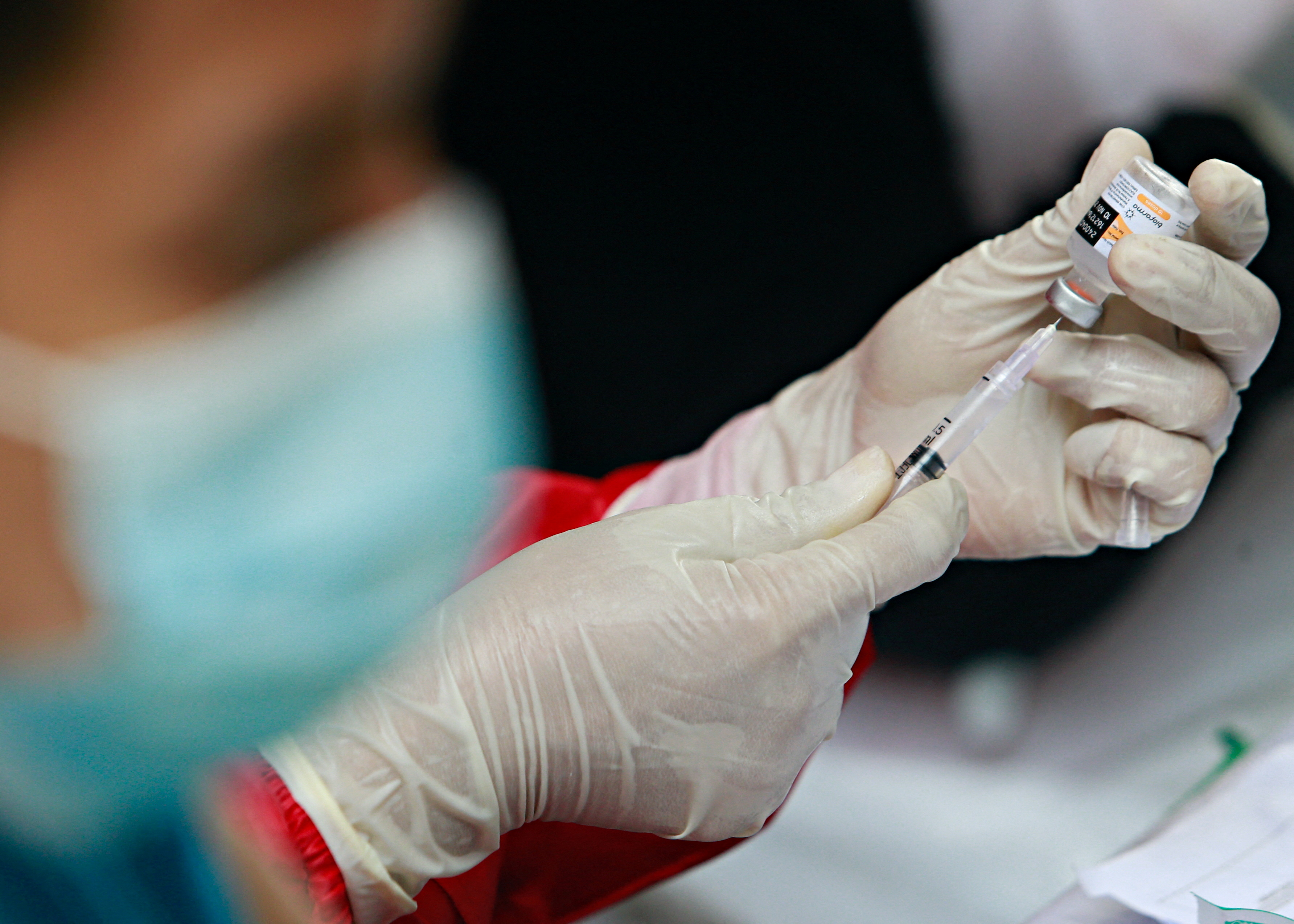 A healthcare worker prepares a coronavirus vaccine dose