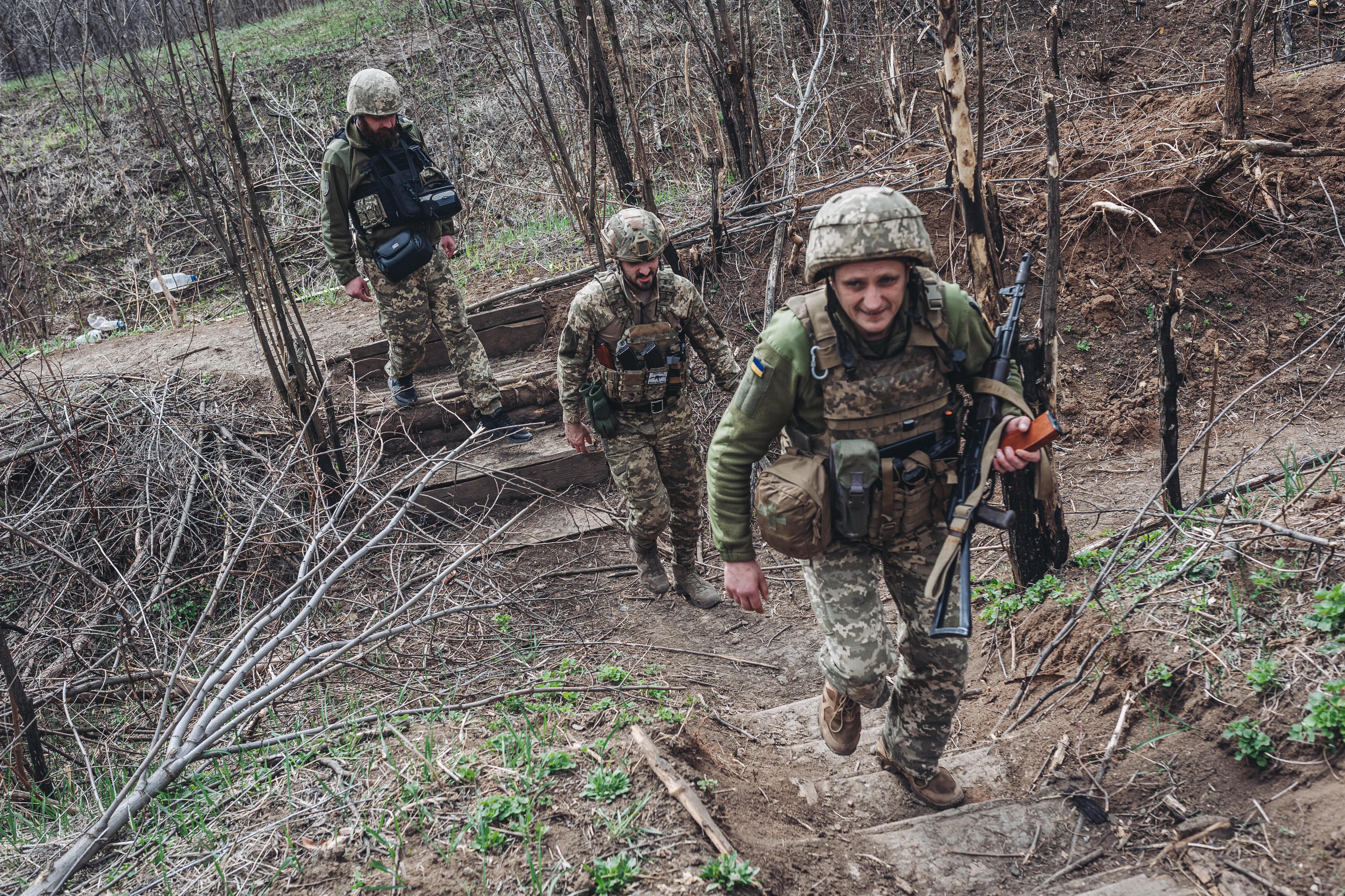 Ukrainian soldiers walk through a Ukrainian front line in the Donbas region