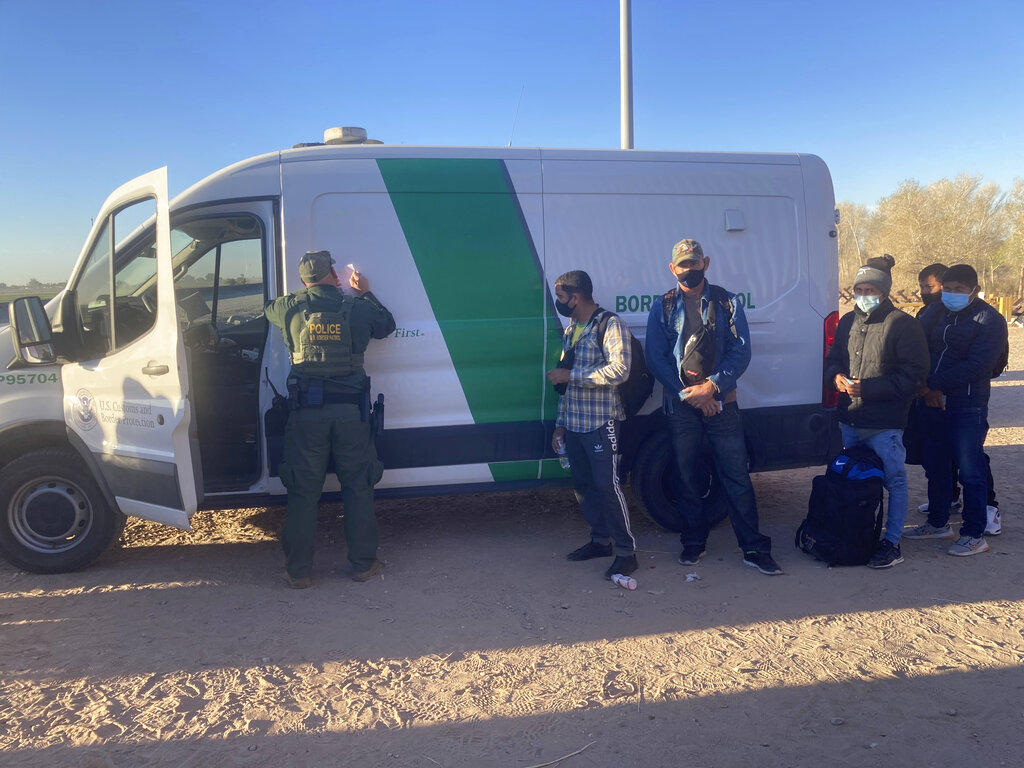 A Border Patrol agent fills out paperwork for migrants who surrendered in Yuma, Arizona, February 5, 2022, after crossing the border illegally from Los Algodones, Mexico. For nationalities that don’t need a visa, Mexico is often the ticket to seeking asylum in the United States
