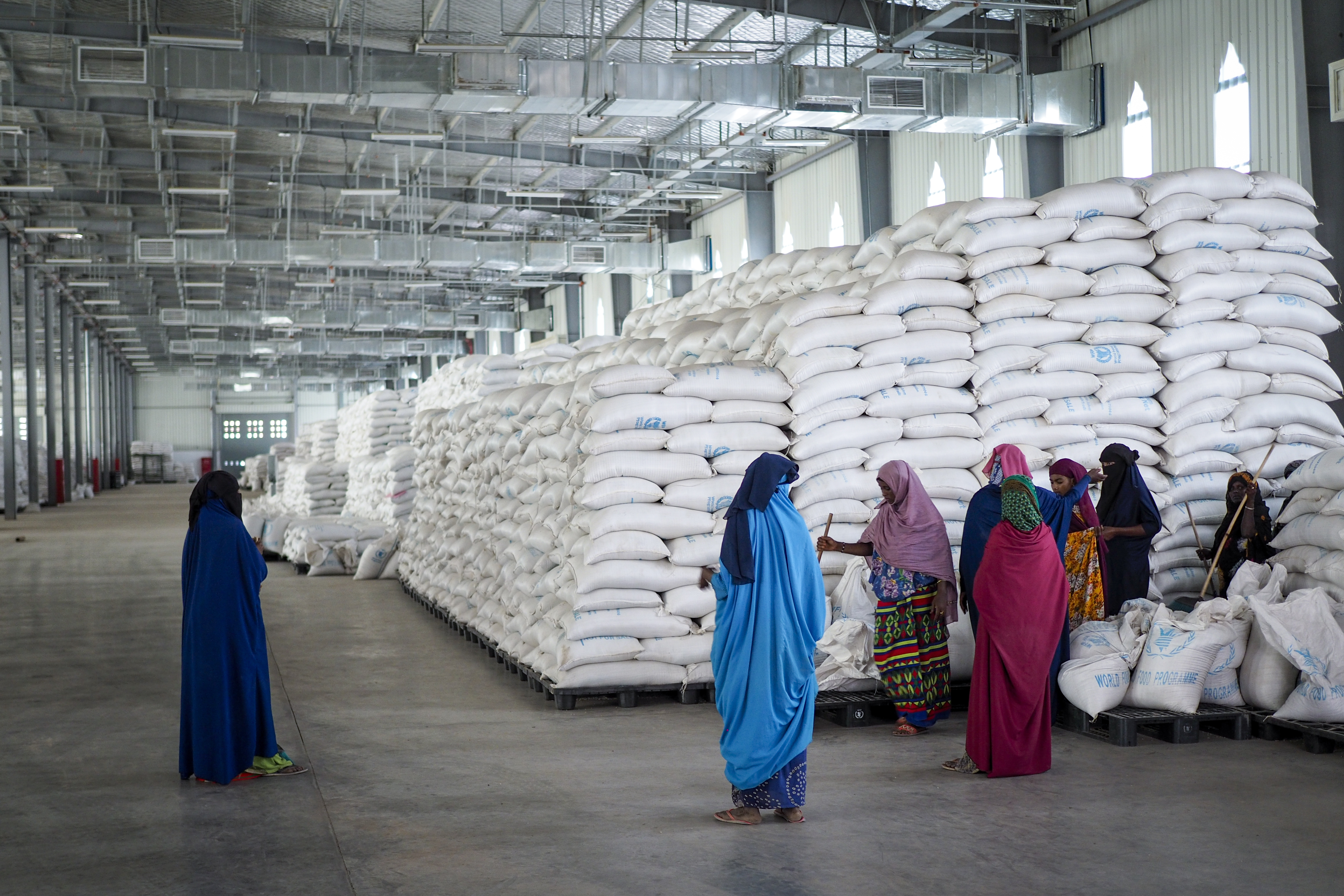 Workers clean the floor as sacks of food earmarked for the Tigray and Afar regions sits in piles