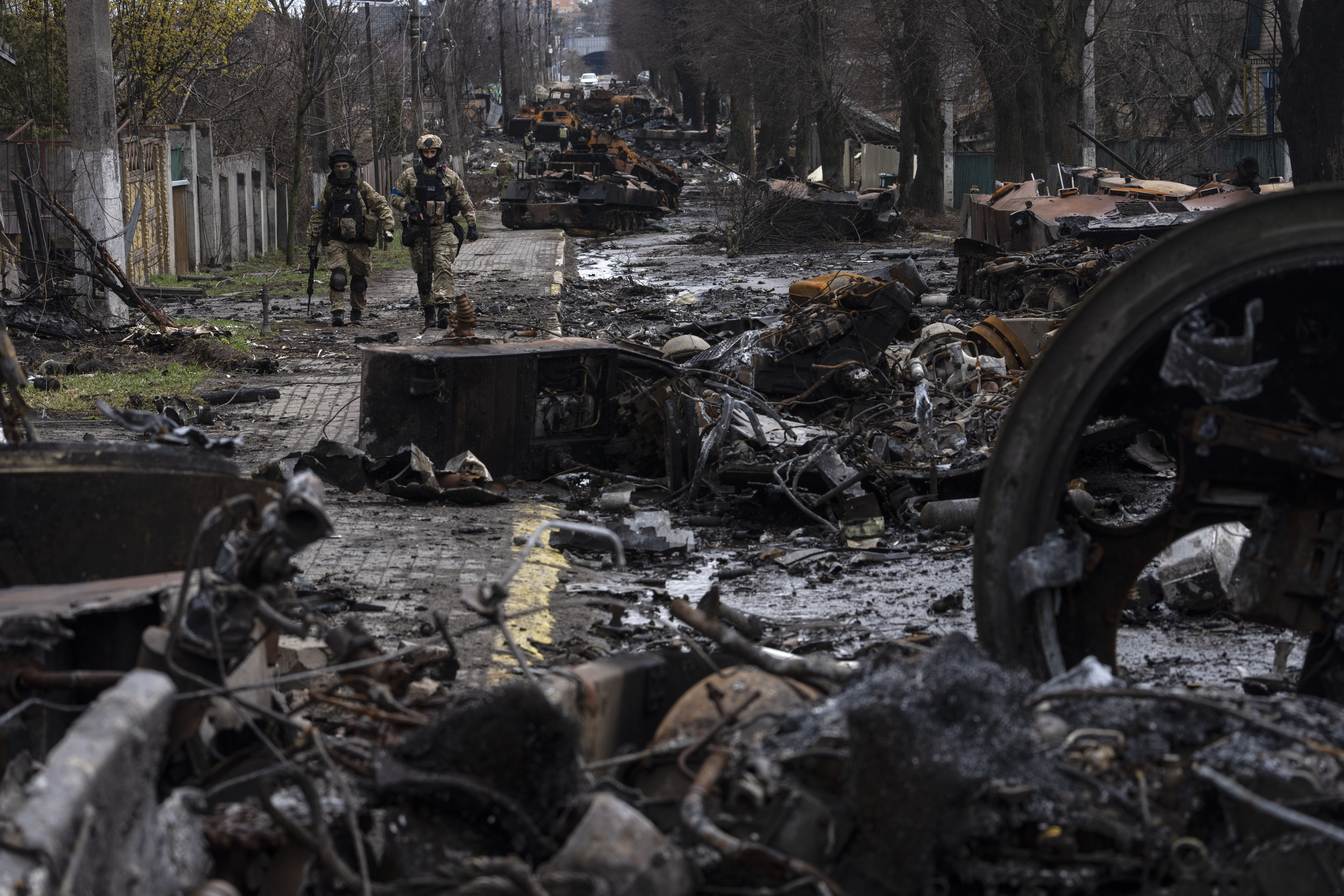 Soldiers walk amid destroyed Russian tanks in Bucha, on the outskirts of Kyiv, Ukraine, April 3, 2022