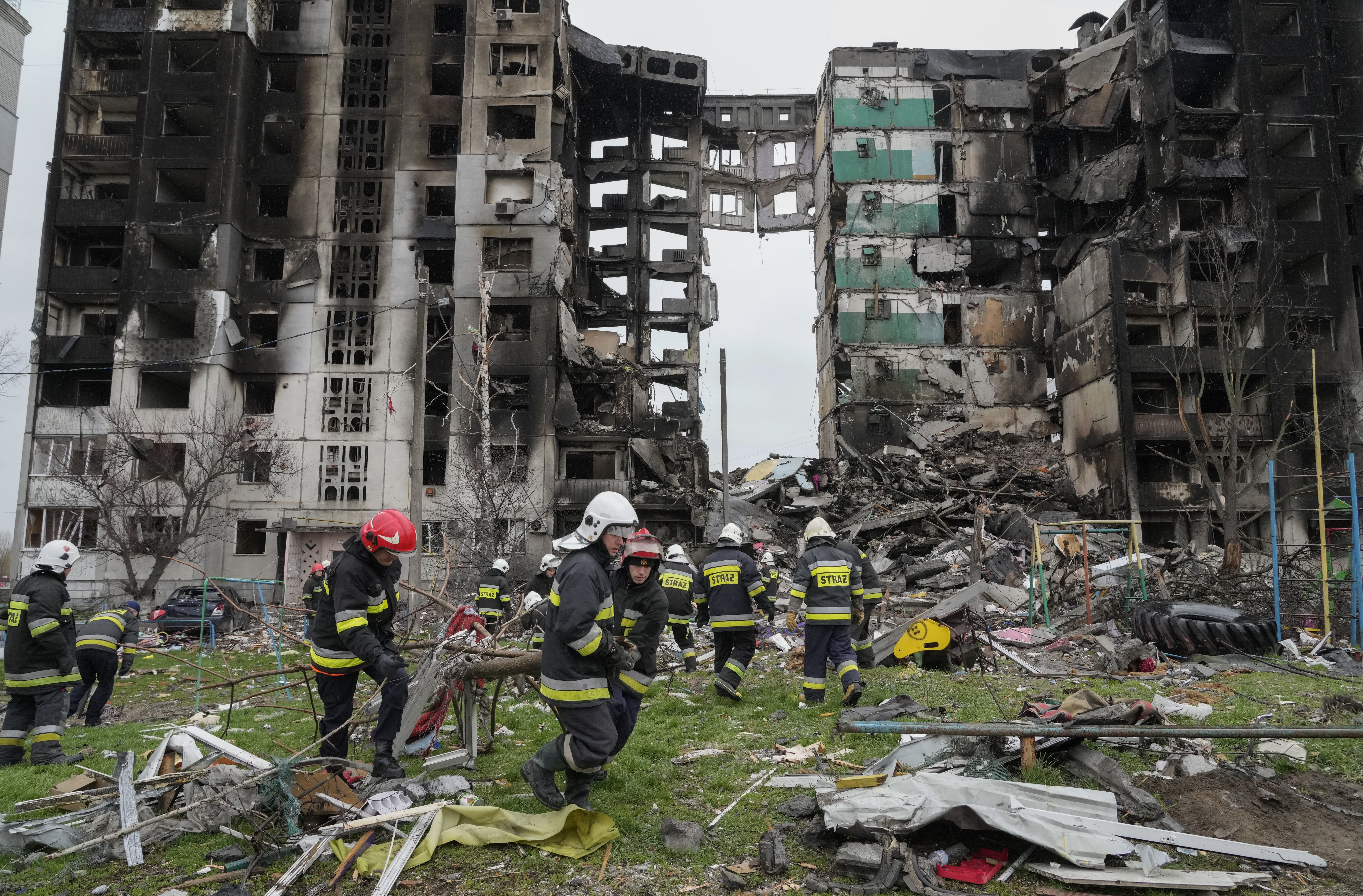 Emergency workers carry debris from a multi-storey building destroyed in a Russian air raid at the beginning of the Russia-Ukraine war in Borodyanka, close to Kyiv, Ukraine