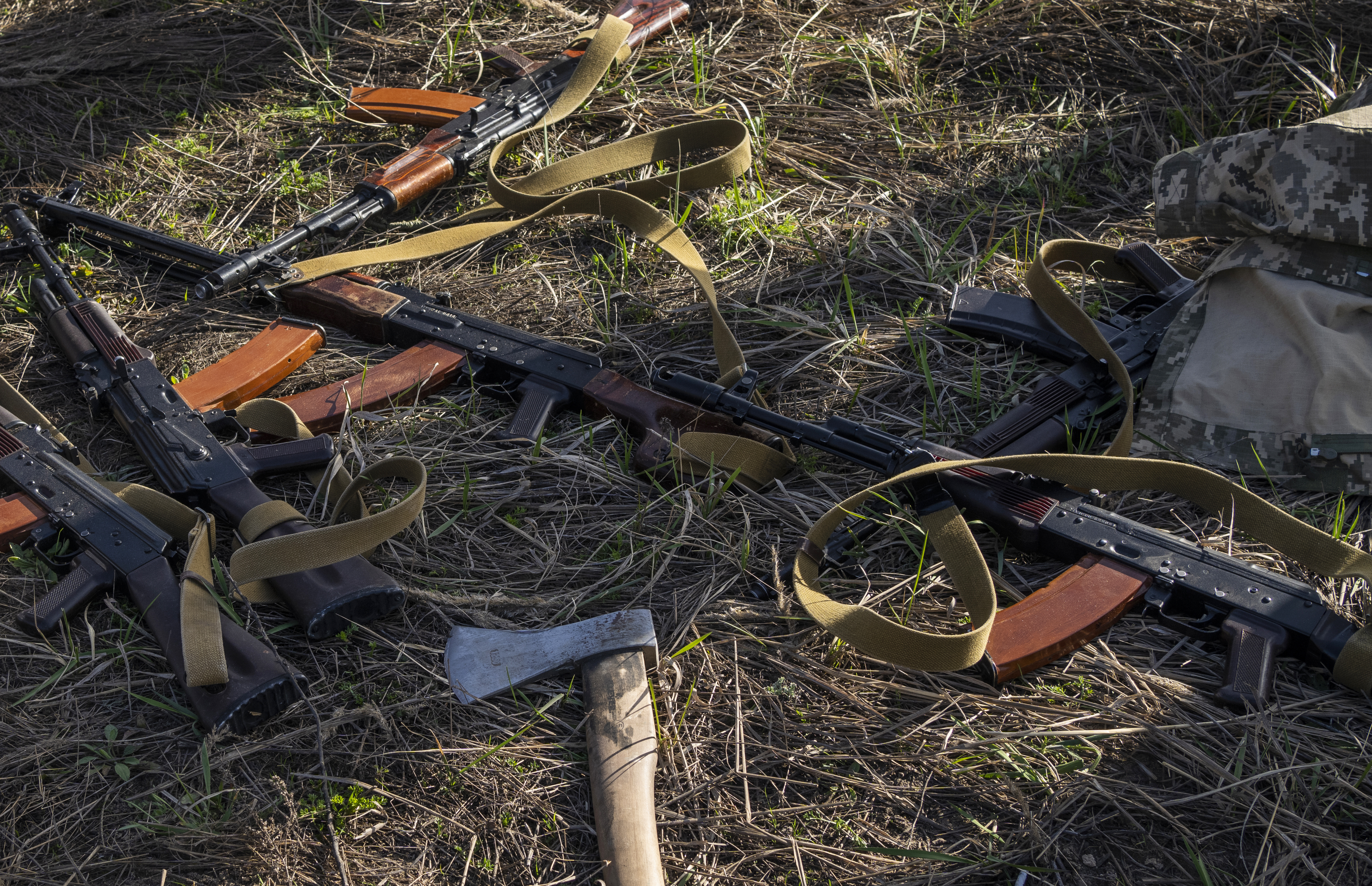 Rifles and an axe lay in a field where Ukrainian soldiers dig a trench in case of another Russian invasion, in Bucha, on the outskirts of Kyiv, Ukraine
