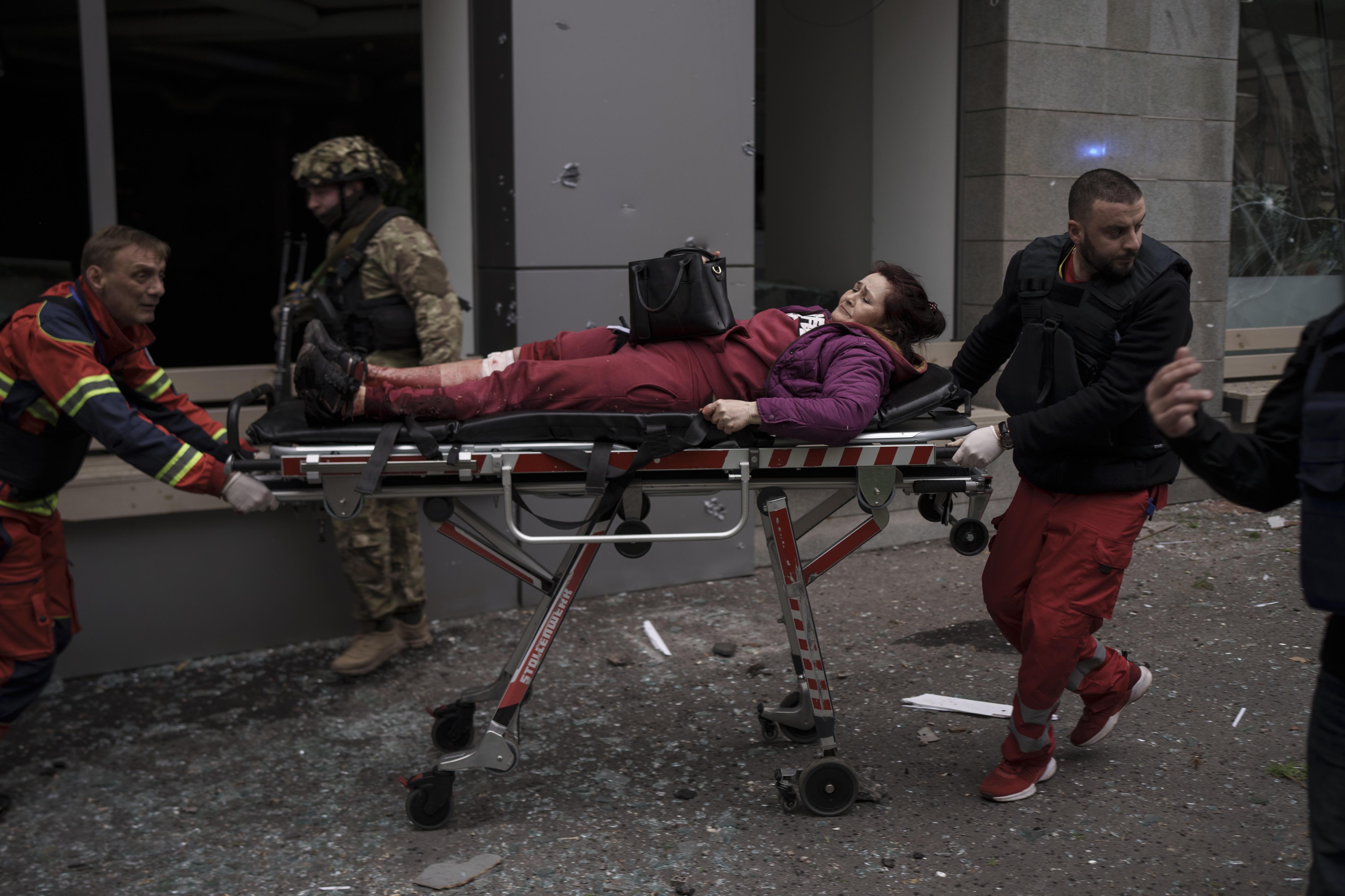 A woman is taken to an ambulance after being injured in Russian bombardment in Kharkiv, Ukraine, on April 17, 2022