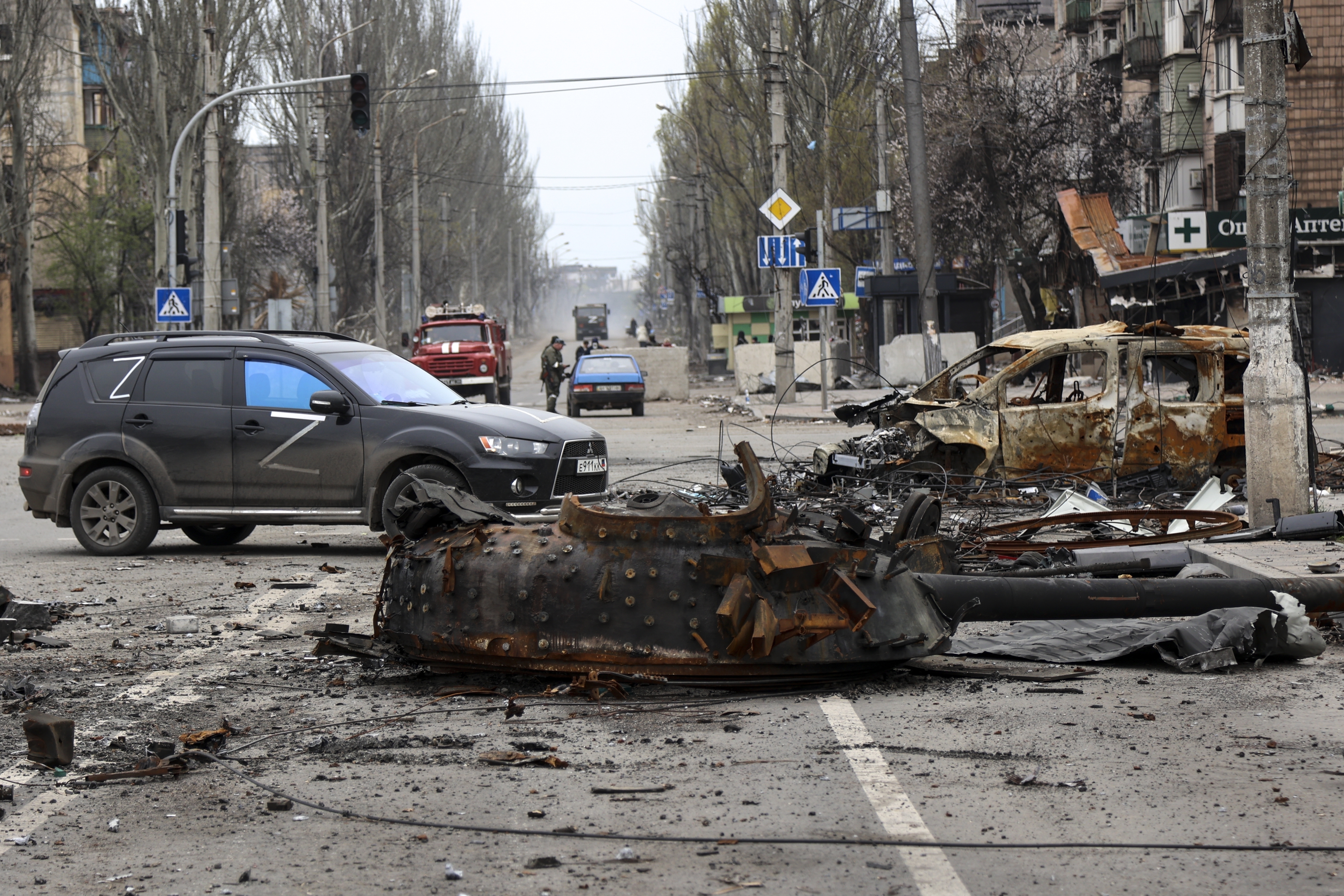 Part of a destroyed tank and a burned vehicle sit in an area controlled by Russian-backed separatist forces in Mariupol