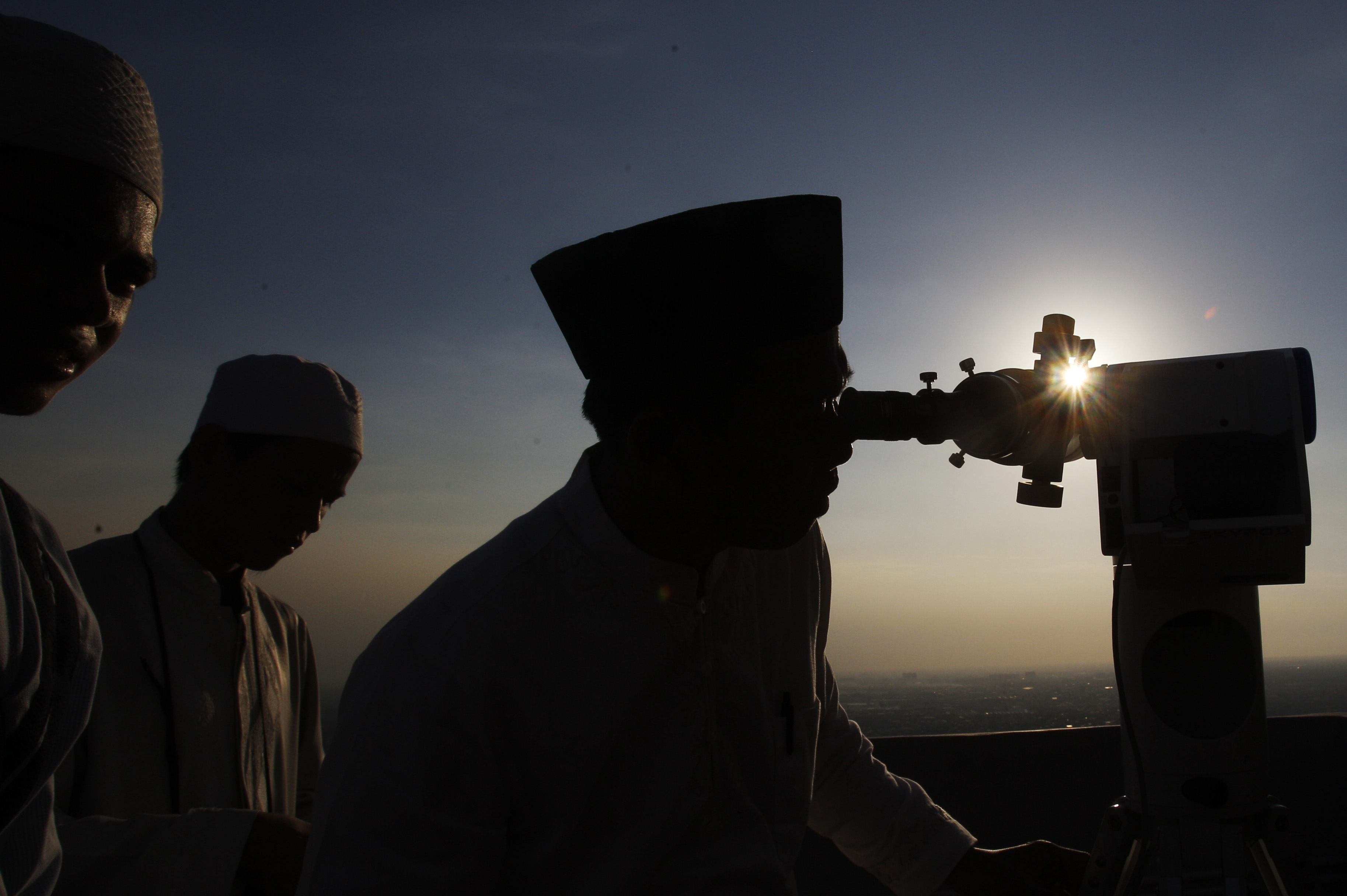 Muslim leaders are silhouetted as they scan the horizon for the crescent Moon that will determine the beginning of the holy fasting month of Ramadan, in Jakarta, Indonesia