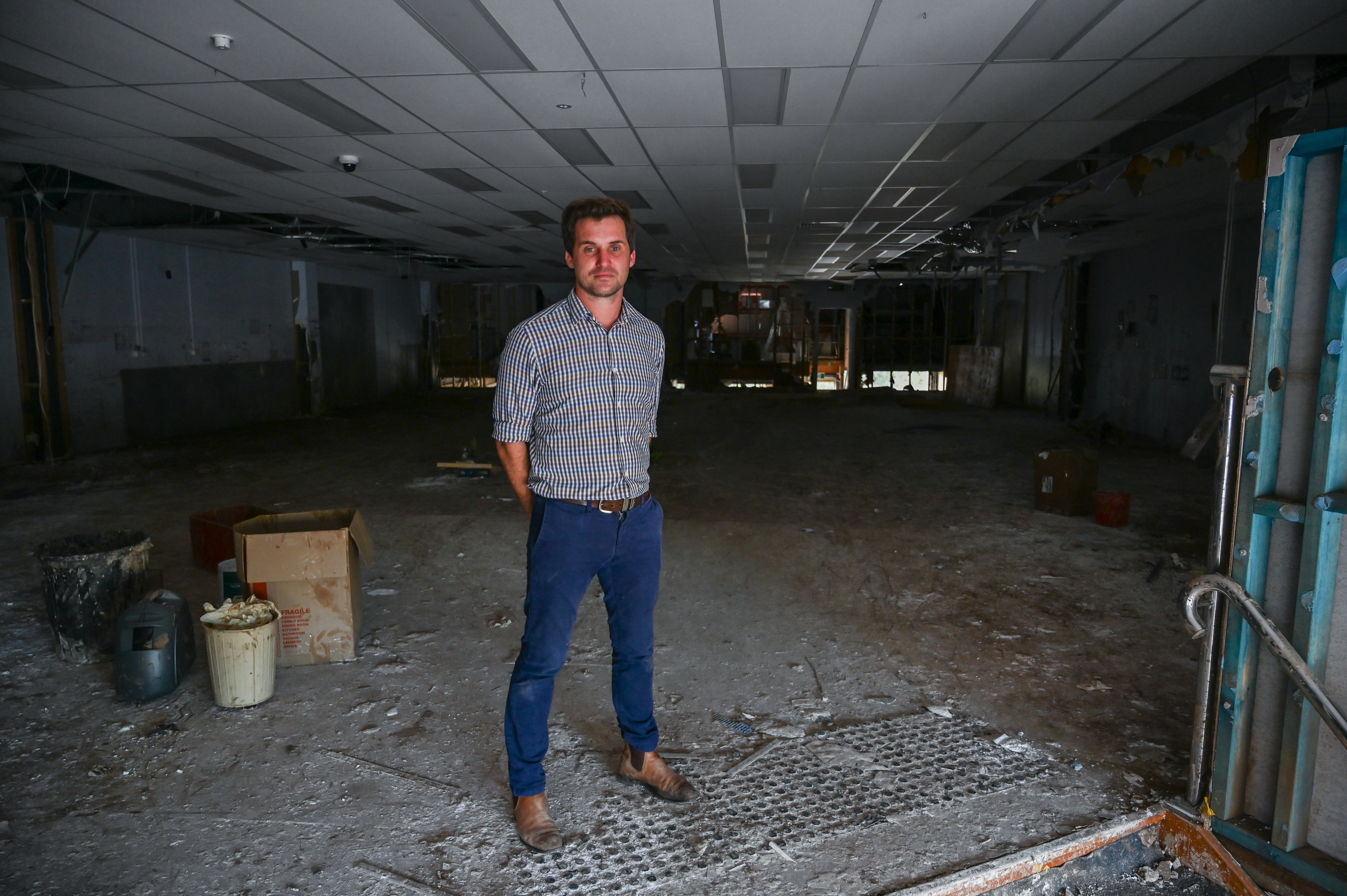 Lismore pharmacy owner Kyle Wood stands in what remains of his business after February’s floods. He thought the shop’s elevated position would protect it from the rising waters