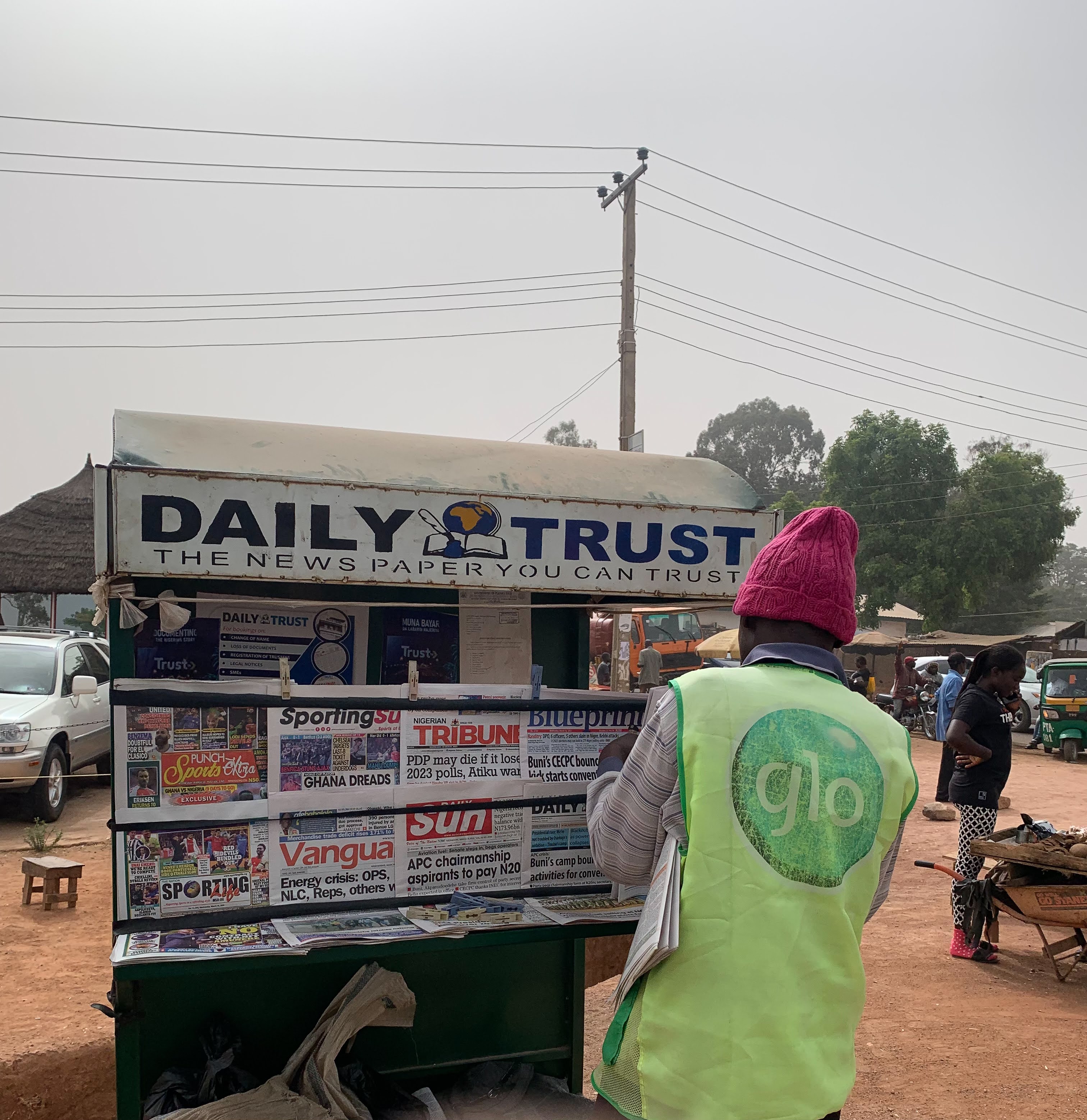 A newspaper vendor displays the day’s newspapers on a roadside in Jos