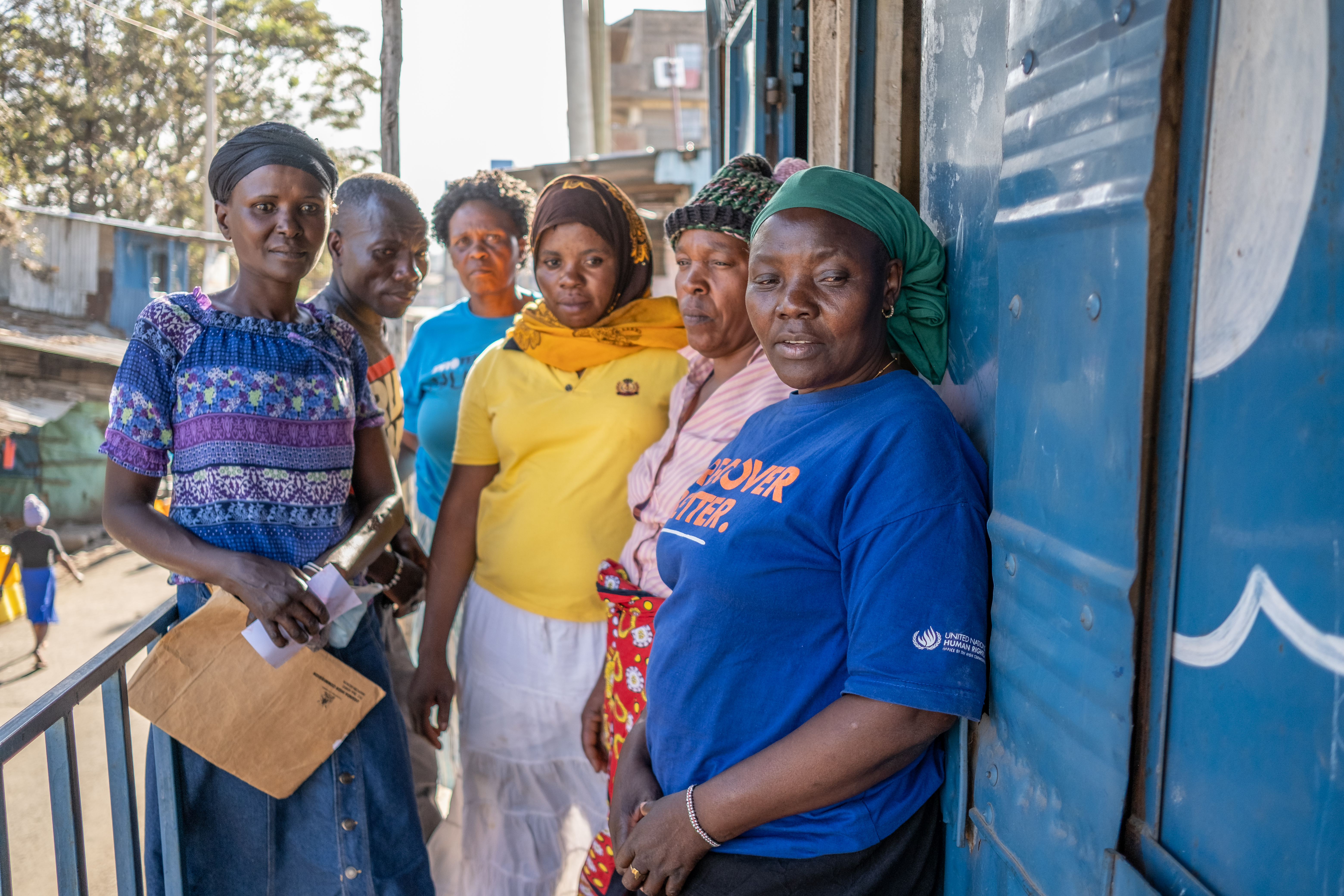 A photo of six women stand outside their office on Mau Mau Road in Mathare.