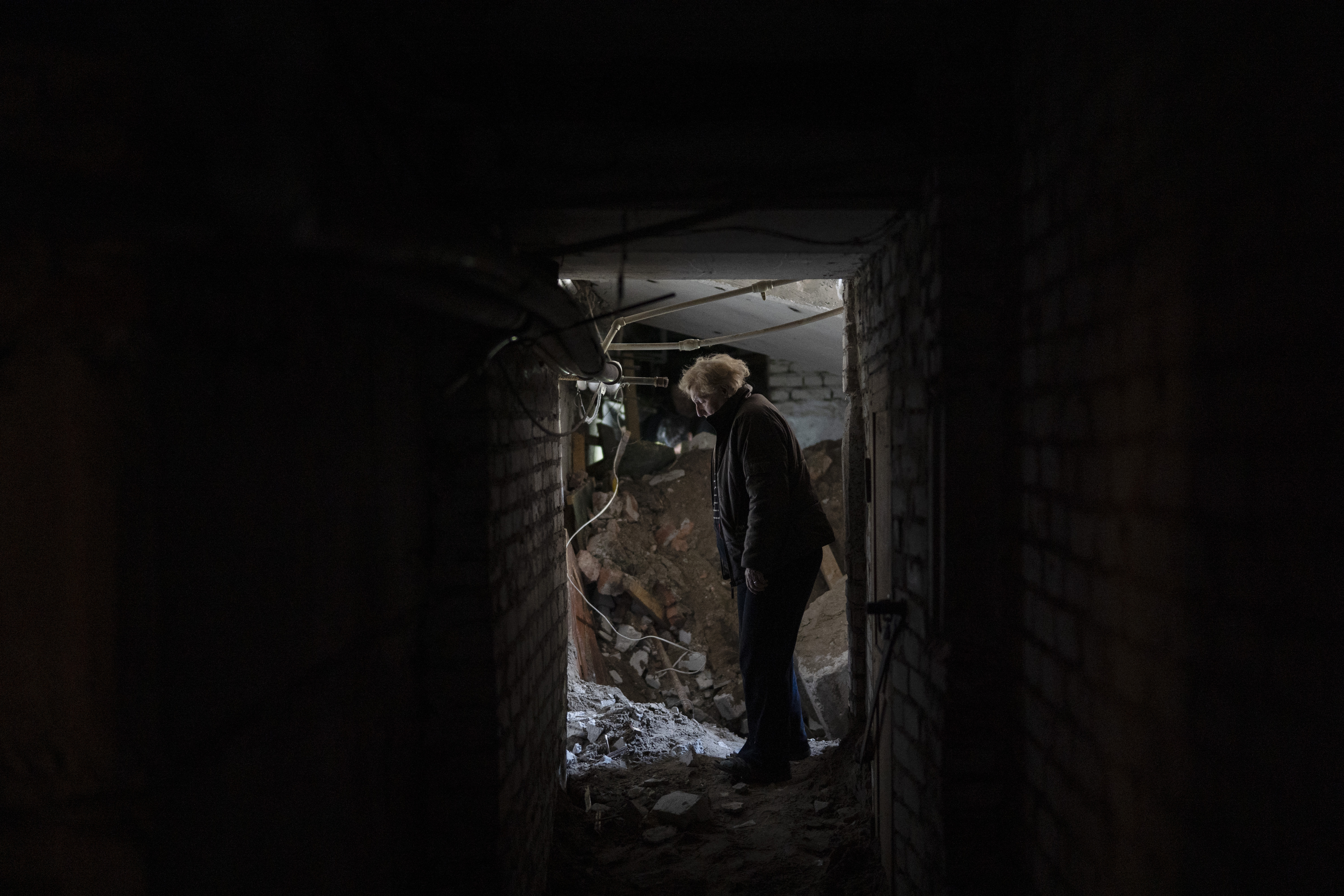 Lilia stands near to where a bomb damaged the basement of a residential building and killed, according to the residents, an eight-year-old girl in Lyman, Ukraine, on Tuesday, April 26, 2022