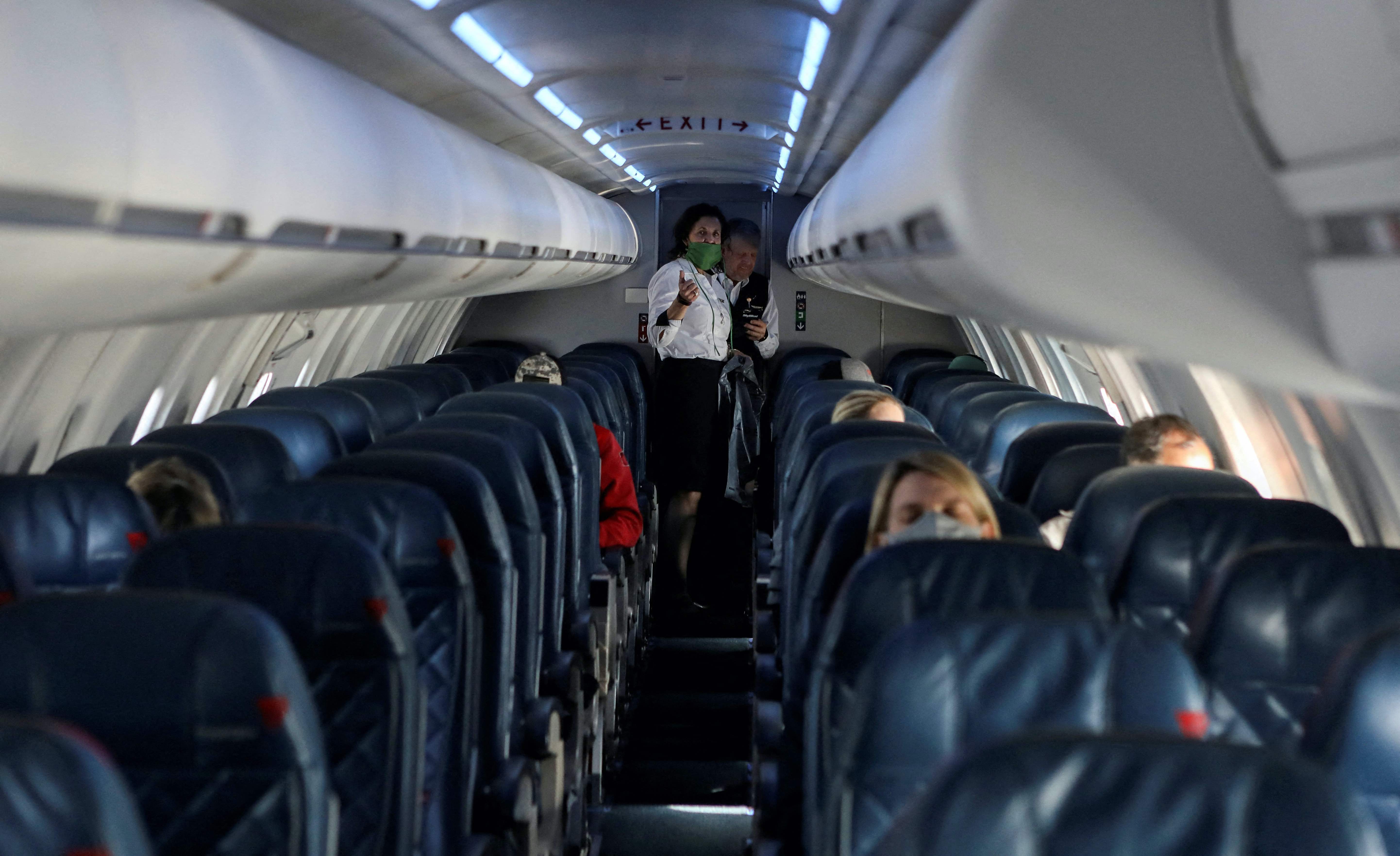 Flight attendants talk on a Delta Airlines flight