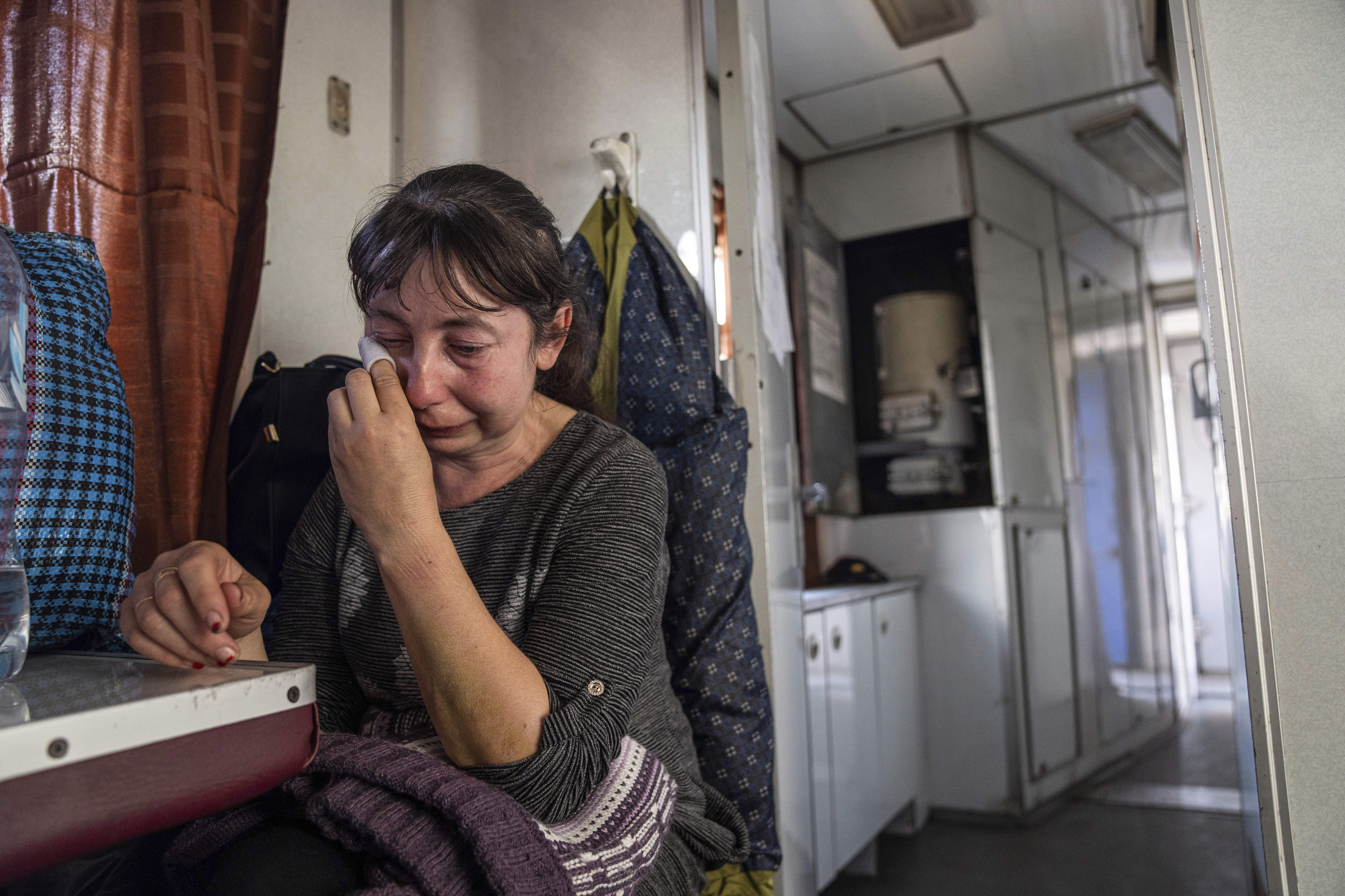 A woman from Luhansk region cries while sitting on an evacuation train in Pokrovsk, eastern Ukraine, on Tuesday, April 26, 2022